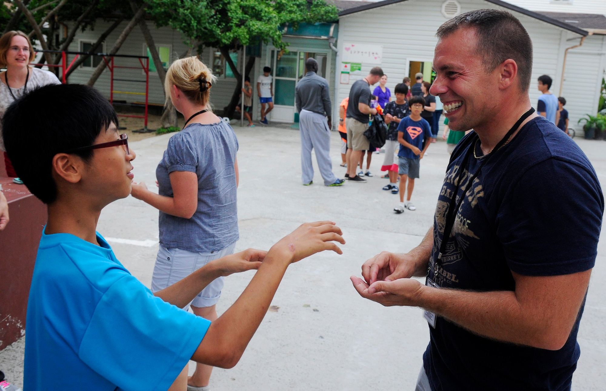 A child shares a laugh with Staff Sgt. Angelo Taralb, 158th Fighter Wing, Vermont Air National Guard, at a Welfare Facility in Gunsan City, Republic of Korea, Aug. 18, 2015. Airmen from Kunsan Air Base visit the facility monthly to bolster relationships with the local community. (U.S. Air Force photo by Staff Sgt. Nick Wilson/Released)