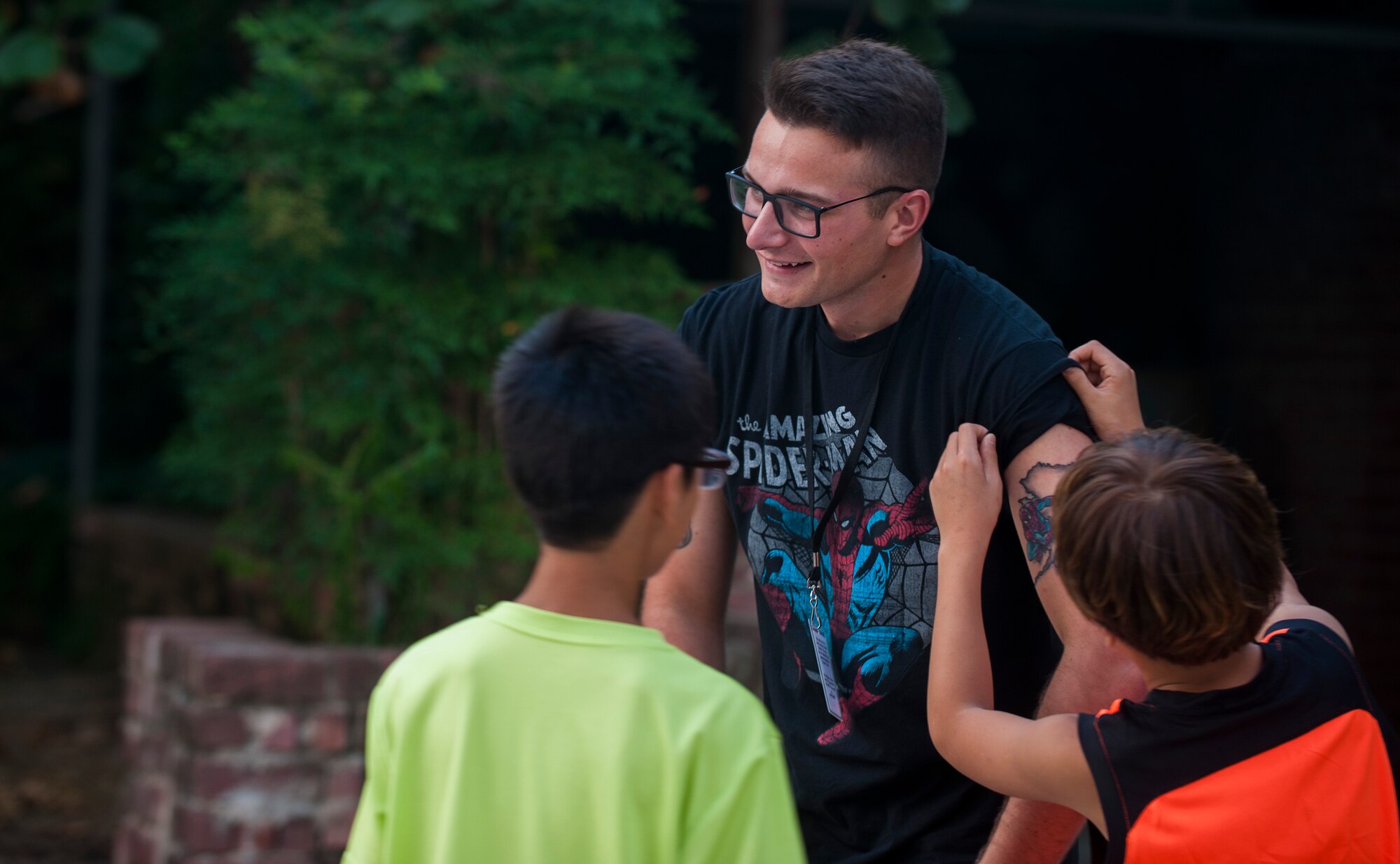 Airman 1st Class Calib Anderson, 8th Logistics Readiness Squadron general purpose mechanic, Kunsan Air Base, Republic of Korea, shows his Spiderman tattoo to children at a Welfare Facility in Gunsan City, ROK, Sept. 1. 2015. Airmen from Kunsan AB visit the facility monthly to bolster relationships with the local community. (U.S. Air Force photo by Staff Sgt. Nick Wilson/Released)