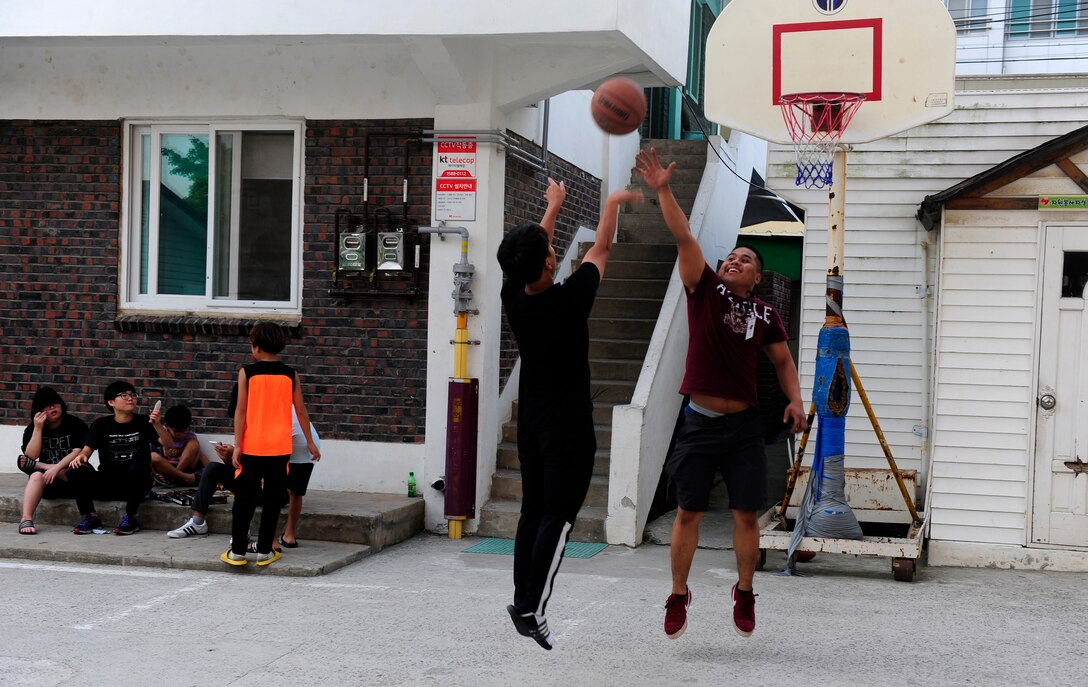 Senior Airman Evion Diaz, 8th Logistics Readiness Squadron vehicle maintenance technician, Kunsan Air Base, Republic of Korea, plays basketball with a child at a Welfare Facility in Gunsan City, ROK, Sept. 1. 2015. The volunteer program helps Airmen develop leadership skills and become positive role models within the community. (U.S. Air Force photo by Staff Sgt. Nick Wilson/Released)