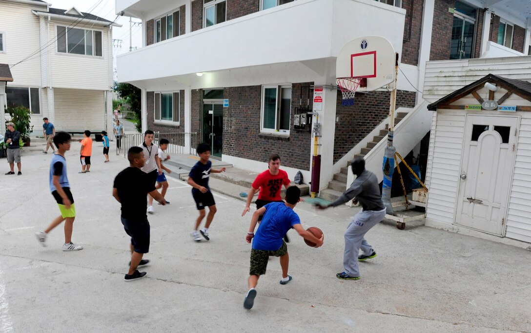 Volunteer Airmen from Kunsan Air Base, Republic of Korea, play basketball with children at a Welfare Facility in Gunsan City, ROK, Aug. 18, 2015. The 8th Fighter Wing chapel sets up monthly visits to the facility where Airmen can play games and socialize with the children. (U.S. Air Force photo by Staff Sgt. Nick Wilson/Released)