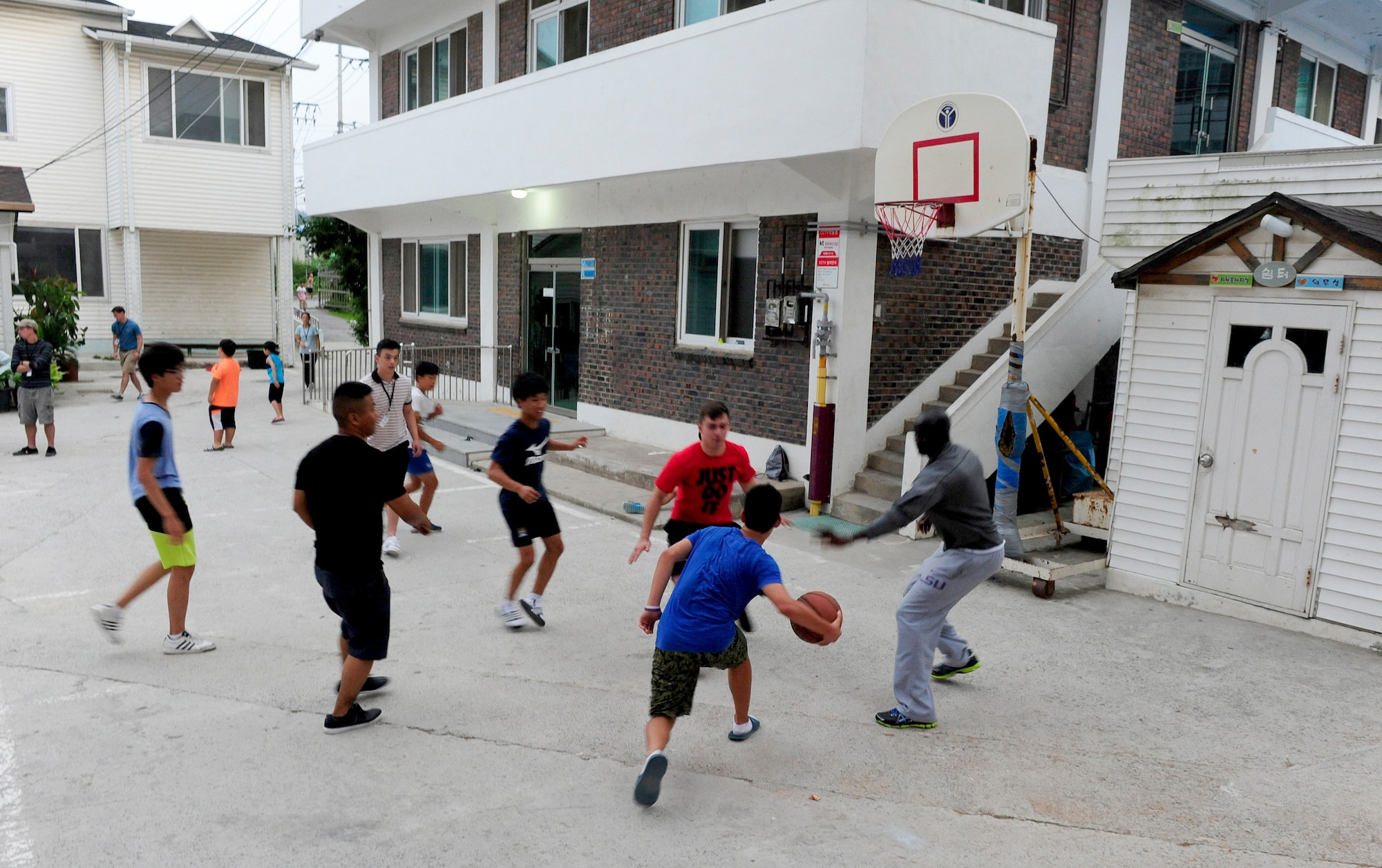 Volunteer Airmen from Kunsan Air Base, Republic of Korea, play basketball with children at a Welfare Facility in Gunsan City, ROK, Aug. 18, 2015. The 8th Fighter Wing chapel sets up monthly visits to the facility where Airmen can play games and socialize with the children. (U.S. Air Force photo by Staff Sgt. Nick Wilson/Released)