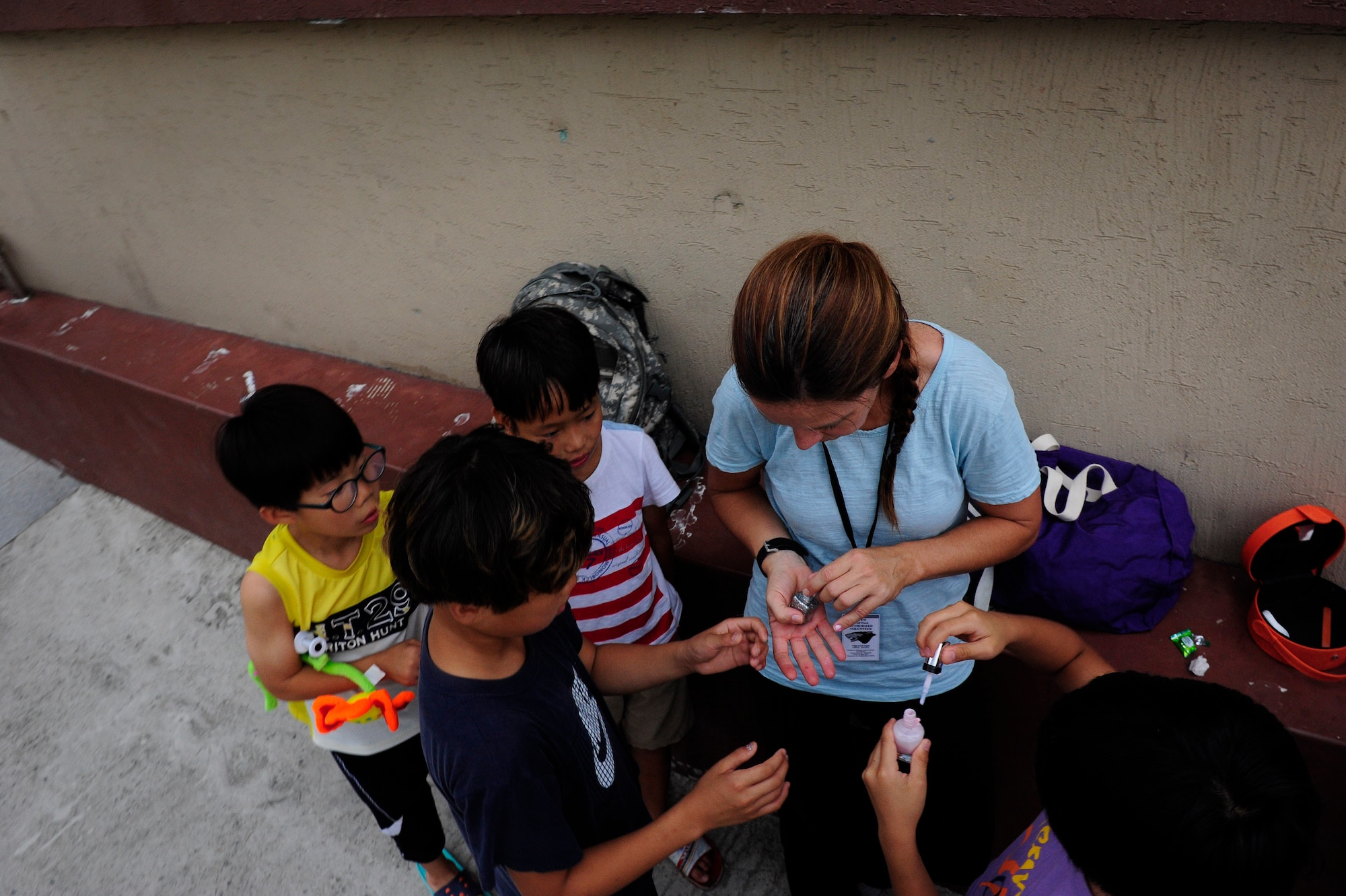 Senior Master Sgt. Cynthia Fitzgerald, 134th Expeditionary Force Squadron, Vermont Air National Guard, South Burlington, passes out finger nail polish to children at a Welfare Facility in Gunsan City, Republic of Korea, Aug. 18, 2015. More than 60 children live in the facility where the Airman volunteered. (U.S. Air Force photo by Staff Sgt. Nick Wilson/Released)