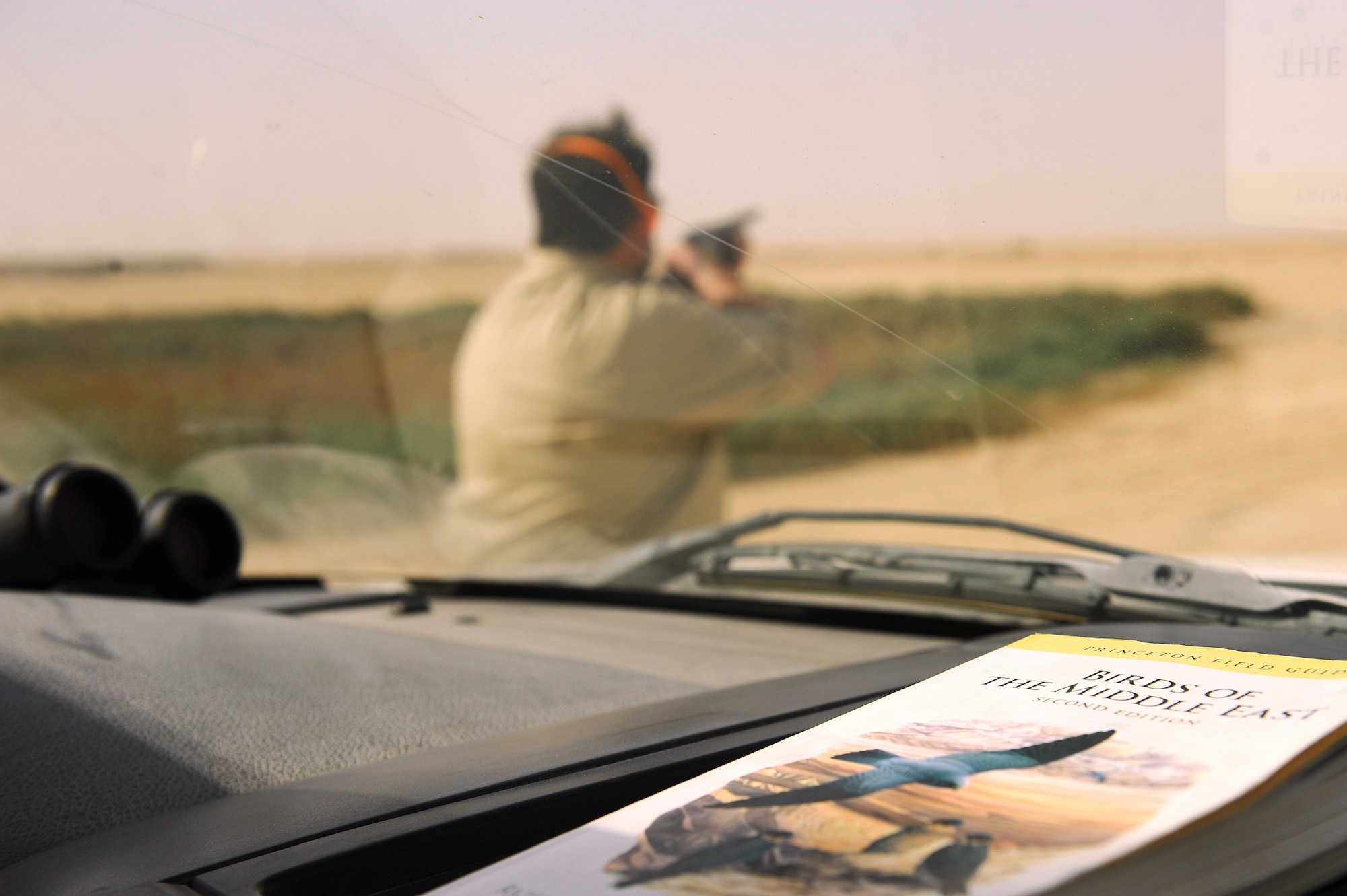 Dave Tresham, United States Department of Agriculture wildlife biologist, disperses birds settling in an area known as the "Green Mile," a manmade sewage runoff expanse with a lush, green environment that provides food, water and shelter attractive to wild animals at an undisclosed location in Southwest Asia, Sept. 3, 2015. Tresham uses ballistics multiple times per day to frighten birds and other creatures away from the area in an effort to control the wildlife population near aircraft and flightline operations.  (U.S. Air Force photo/Tech. Sgt. Brittany E. Jones)