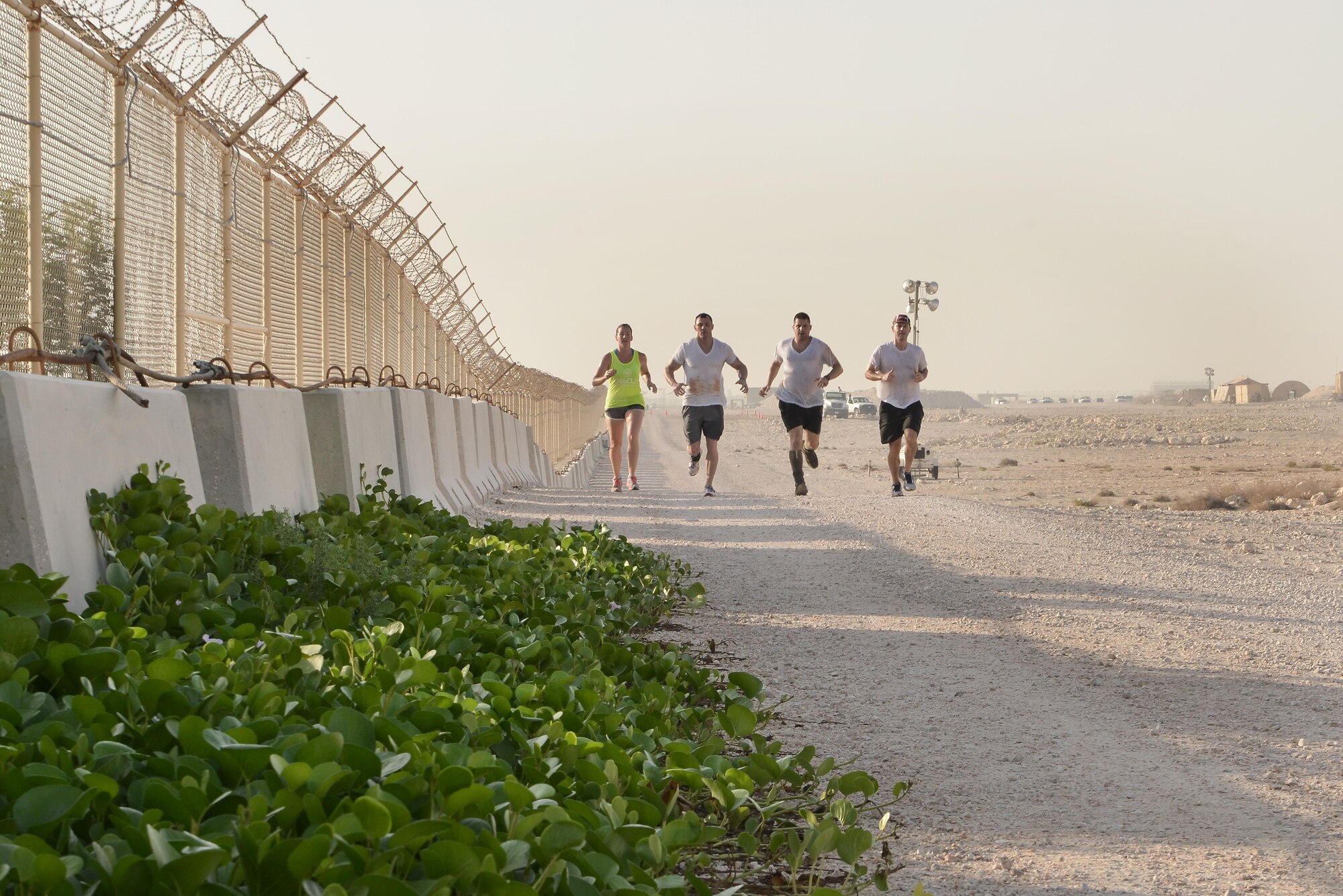 Diversity Day Mud Run participants run to the next section of a two mile course September 20, 2015 at Al Udeid Air Base, Qatar. The mud run challenged 106 runners with several obstacles from low crawling, T-wall climbing, barrier hurdles, and a Ôdeep freezeÕ cold mud pool. The event was held to help spread the word of Diversity Day, an initiative started by the Department of Defense for diversity events held throughout the year. (U.S. Air Force photo/ Staff Sgt. Alexandre Montes)