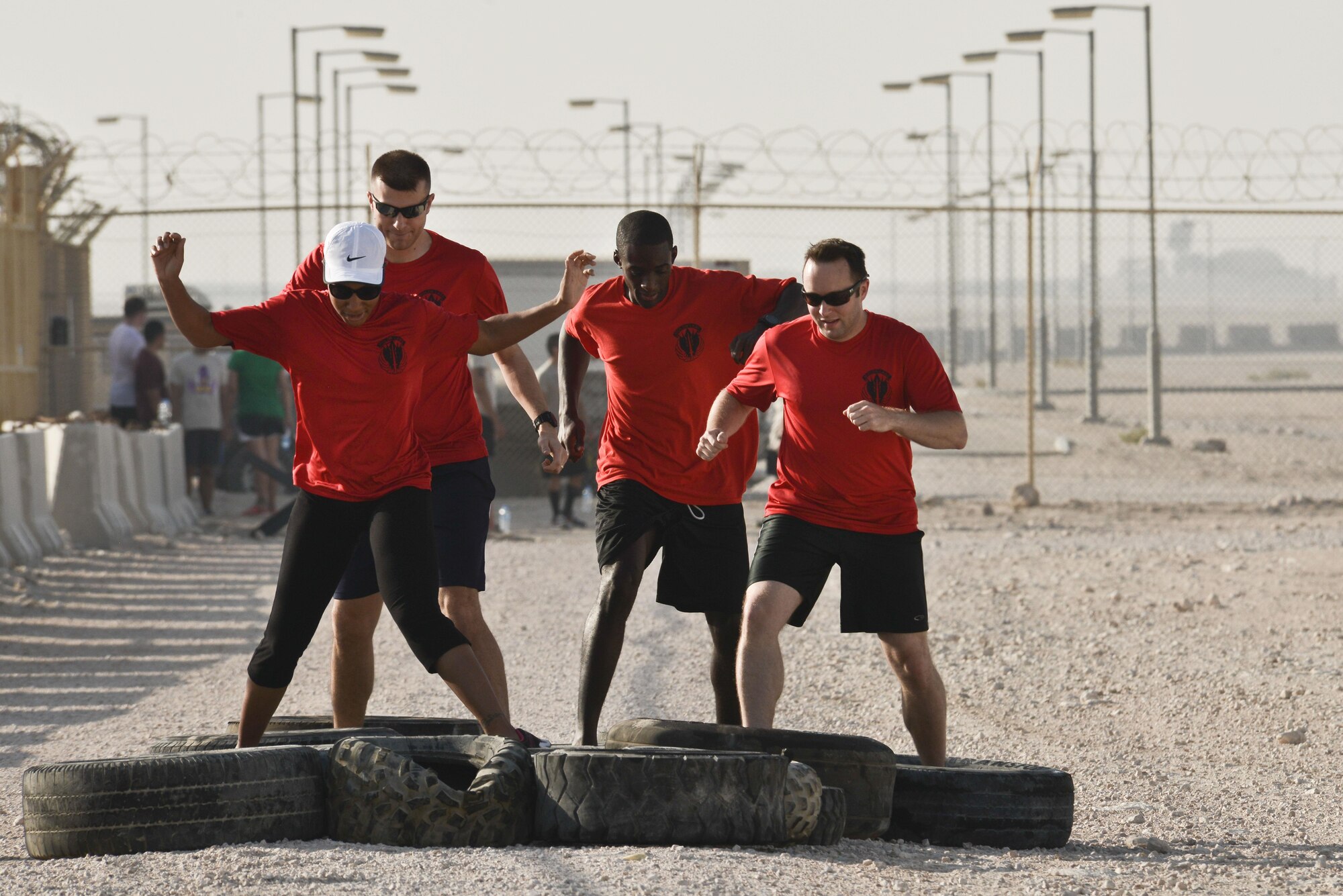 Participants step through the tire obstacle during a Diversity Day mud run September 20, 2015 at Al Udeid Air Base, Qatar.  The mud run challenged 106 runners with a two mile course that contained several obstacles from low crawling, T-wall climbing, barrier hurdles, and a Ôdeep freezeÕ cold mud pool. The event was held to help spread the word of Diversity Day, an initiative started by the Department of Defense for diversity events held throughout the year. (U.S. Air Force photo/ Staff Sgt. Alexandre Montes)  