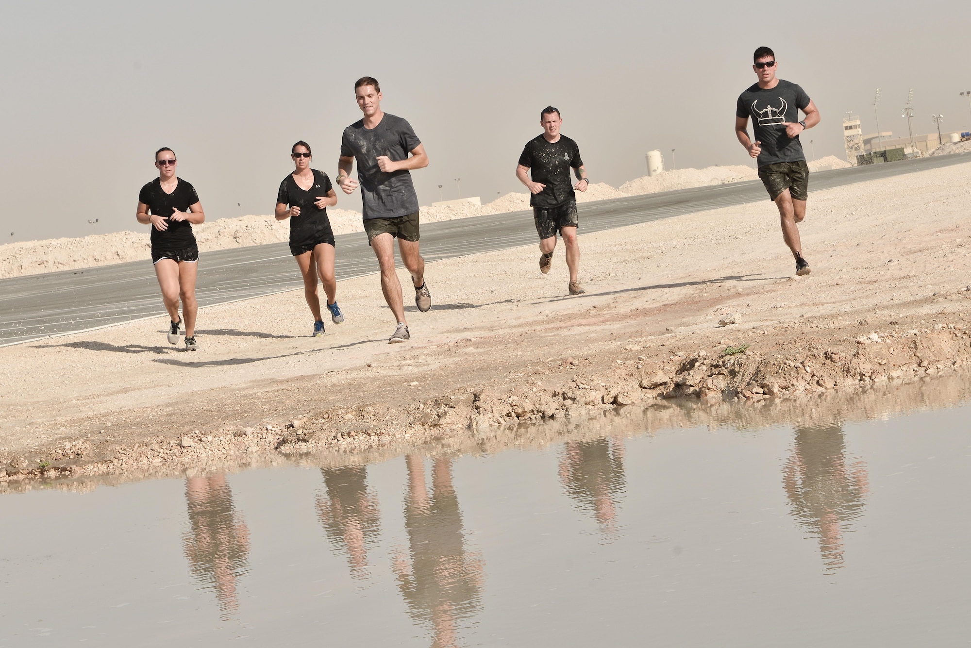 Teams were given their final times as they entered a mud pool at the end of the Diversity Day mud run September 20, 2015 at Al Udeid Air Base, Qatar. The mud run challenged 106 runners with a two mile course that contained several obstacles from low crawling, T-wall climbing, barrier hurdles, and a Ôdeep freezeÕ cold mud pool. The event was held to help spread the word of Diversity Day, an initiative started by the Department of Defense for diversity events held throughout the year. (U.S. Air Force photo/ Staff Sgt. Alexandre Montes)  