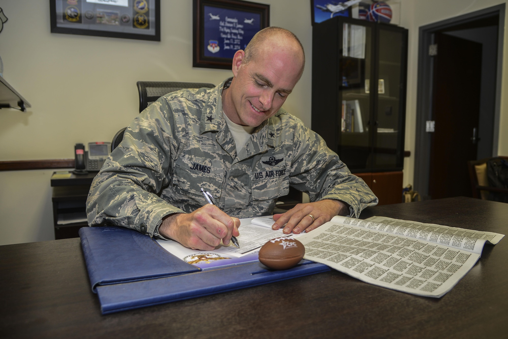 Brig. Gen. Darren James, the 379th Air Expeditionary Wing commander, signs his Combined Federal Campaign-Overseas form Oct.23, 2015 at Al Udeid Air Base, Qatar. The CFC-O campaign lasts from Sept. 21st to Nov. 20th. There are several events that will be held to raise awareness to publicize the opportunity to contribute donations for various charities. (U.S. Air Force photo by Tech. Sgt. Rasheen Douglas) 
