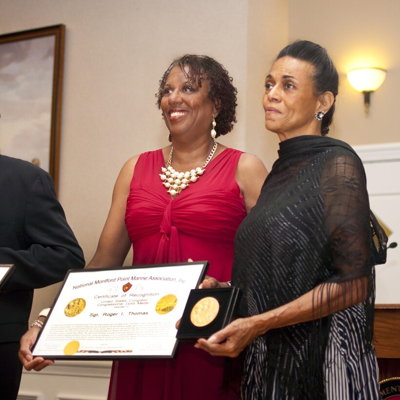 Master Sgt. Rita Thomas, retired, and Tondalier Thomas accept the award for their father Sgt. Roger Thomas, at the Montford Point Marine Association Chapter 32 formal gala at The Clubs of Quantico, Sept. 12. Roger, a native of Washington, D.C., enlisted in the Corps July 2, 1943 and retired from 41 years of government service in 1983. 