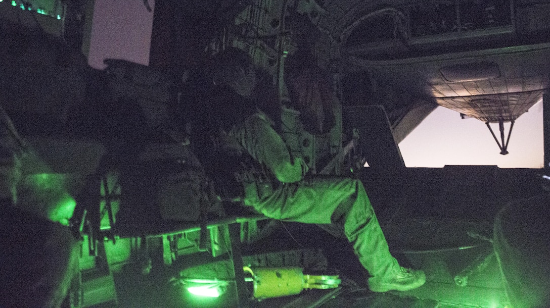 A Marine with Heavy Helicopter Squadron 466 sits in a CH-53E Super Stallion during external-lift training at Marine Corps Base Camp Pendleton, Calif., Sept. 16. Marines with Combat Logistics Battalion 1 and HMH-466 conducted external-lift training to practice effective communication and cooperation between air and ground units in low-light conditions. 