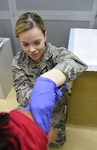 Staff Sgt. Danielle Dowdy, Diabetes Center of Excellence NCO in charge, administers a vaccine to a patient at the DCOE Aug. 28, 2015. The DCOE, which is located at the Wilford Hall Ambulatory Surgical Center at Joint Base San Antonio-Lackland, Texas, recently established a point-of-service immunizations clinic enabling DCOE personnel to carry and administer vaccines recommended for diabetic patients. (U.S. Air Force photo by Staff Sgt. Jerilyn Quintanilla/Released)