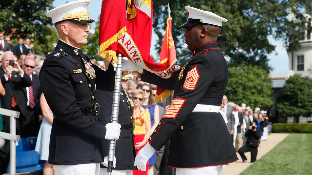 Sergeant Major of the Marine Corps Ronald L. Green, right, hands the Marine Corps Battle Colors to 36th Commandant of the Marine Corps Gen. Joseph F. Dunford, Jr., during the passage of command ceremony at Marine Corps Barracks Washington, D.C., Sept. 24, 2015. Gen. Dunford relinquished the position to Gen. Robert B. Neller, the 37th and new Commandant of the Marine Corps. 