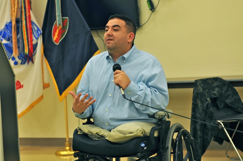 Retired Army Sgt. Manny Mendoza-Valencia talks about his life and love of Hispanic culture to the audience at the 63rd Regional Support Command’s National Hispanic Heritage Month event, Sept. 22, at the headquarters building, Moffett Field, Calif. Valencia, who was one of the guest speakers at the event, lost his legs to an improvised explosive device in Sadr City, Iraq, in 2004.