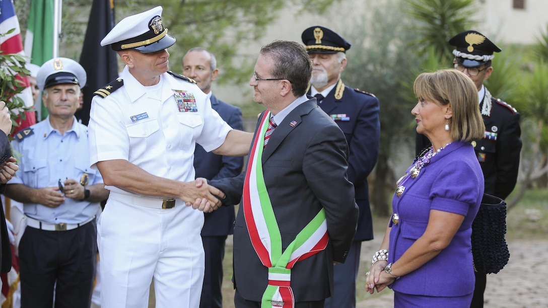 U.S. Navy Lt. Scott Jackson shakes the hand of Armando Glorioso, mayor of Nissoria, during a September 11th remembrance ceremony in Nissoria, Italy, Sept. 22, 2015. Marines and sailors with Special-Purpose Marine Air-Ground Task Force Crisis Response-Africa and other military members out of Naval Air Station Sigonella, Sicily, were invited by the mayor to participate in their annual ceremony to remember the global impact of the events on 9/11. 