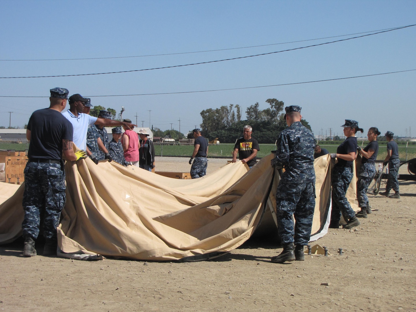 Members of the DLA Distribution Operations Team San Joaquin Navy Reserve unit work in unison with DLA Distribution Expeditionary team members at DLA Distribution San Joaquin, Calif., during the Expeditionary Academy. The team is working together in constructing the air beam tent. 