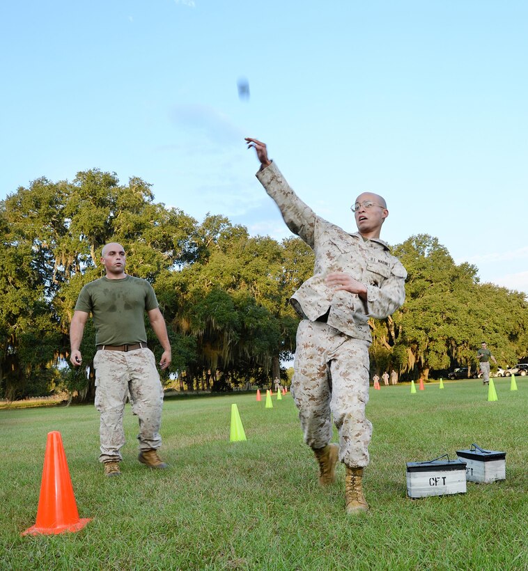 Cpl. Gregory Perez, (right) administrative specialist, Military Personnel, Marine Corps Logistics Base Albany, throws a simulated grenade as he navigates through the maneuver-under-fire portion of the Marine Corps Combat Fitness Test, here, Sept. 22.