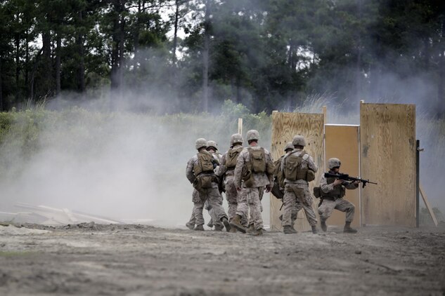 Marines with 2nd Battalion, 2nd Marine Regiment rush into a breached door after an urban charge detonated during a demolitions exercise with 2nd Combat Engineer Battalion at Engineer Training Area  7 on Camp Lejeune, N.C., Sept. 22, 2015.  Marines with 2/2 increased their proficiency and knowledge with various charges and techniques with the help of 2nd CEB.  (U. S. Marine Corps photo by Cpl. Alexander Mitchell/released)