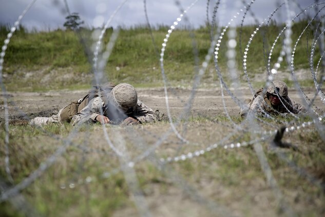 Marines with 2nd Battalion, 2nd Marine Regiment lay in the prone while they set up a bangalore charge to destroy a wire trap during a demolitions exercise with 2nd Combat Engineer Battalion at Engineer Training Area 7 on Camp Lejeune, N.C., Sept. 22, 2015.  Marines with 2/2 increased their proficiency and knowledge with various charges and techniques with the help of 2nd CEB.  (U. S. Marine Corps photo by Cpl. Alexander Mitchell/released)