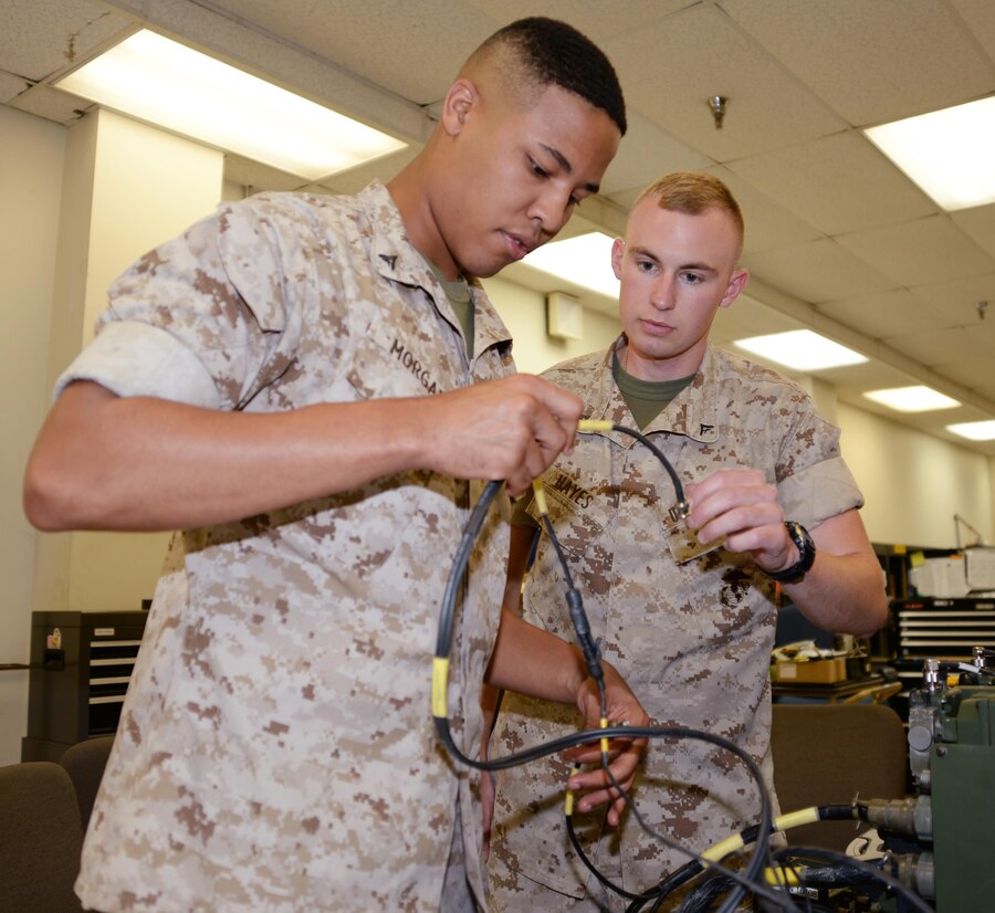 Lance Cpl. Iohnathan Morgan (left) and Lance Cpl. Jeremy Hayes, both ground radio intermediate repairers with Maintenance Company, Combat Logistics Battalion-451, conduct a function check on a Tactical Operations Center Intercommunication System at Marine Depot Maintenance Command during their annual training aboard Marine Corps Logistics Base Albany, Sept. 22.
