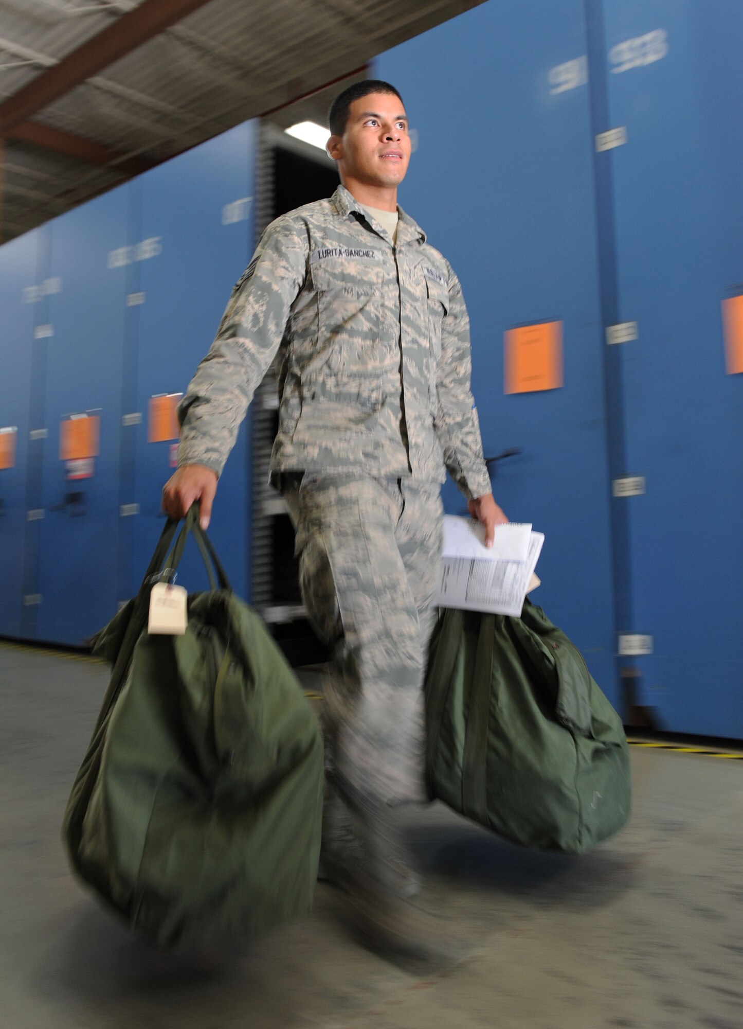 Staff Sgt. Jose Lurita-Sanchez, 81st Diagnostic and Therapeutics Squadron pharmacy support NCO in charge, carries his mobility bags to the next station during a deployment exercise at the supply warehouse Sept. 24, 2015, Keesler Air Force Base, Miss. The exercise scenario tested the mission readiness of Team Keesler members for world-wide deployments. (U.S. Air Force photo by Kemberly Groue)