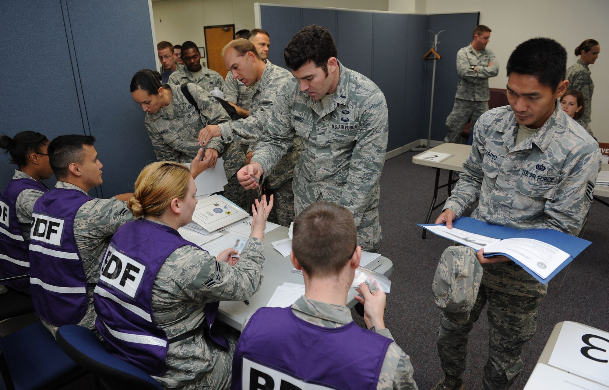 Airmen process through the deployment eligibility line during a deployment exercise at the Taylor Logistics Center Sept. 24, 2015, Keesler Air Force Base, Miss. The exercise scenario tested the mission readiness of Team Keesler members for world-wide deployments. (U.S. Air Force photo by Kemberly Groue)