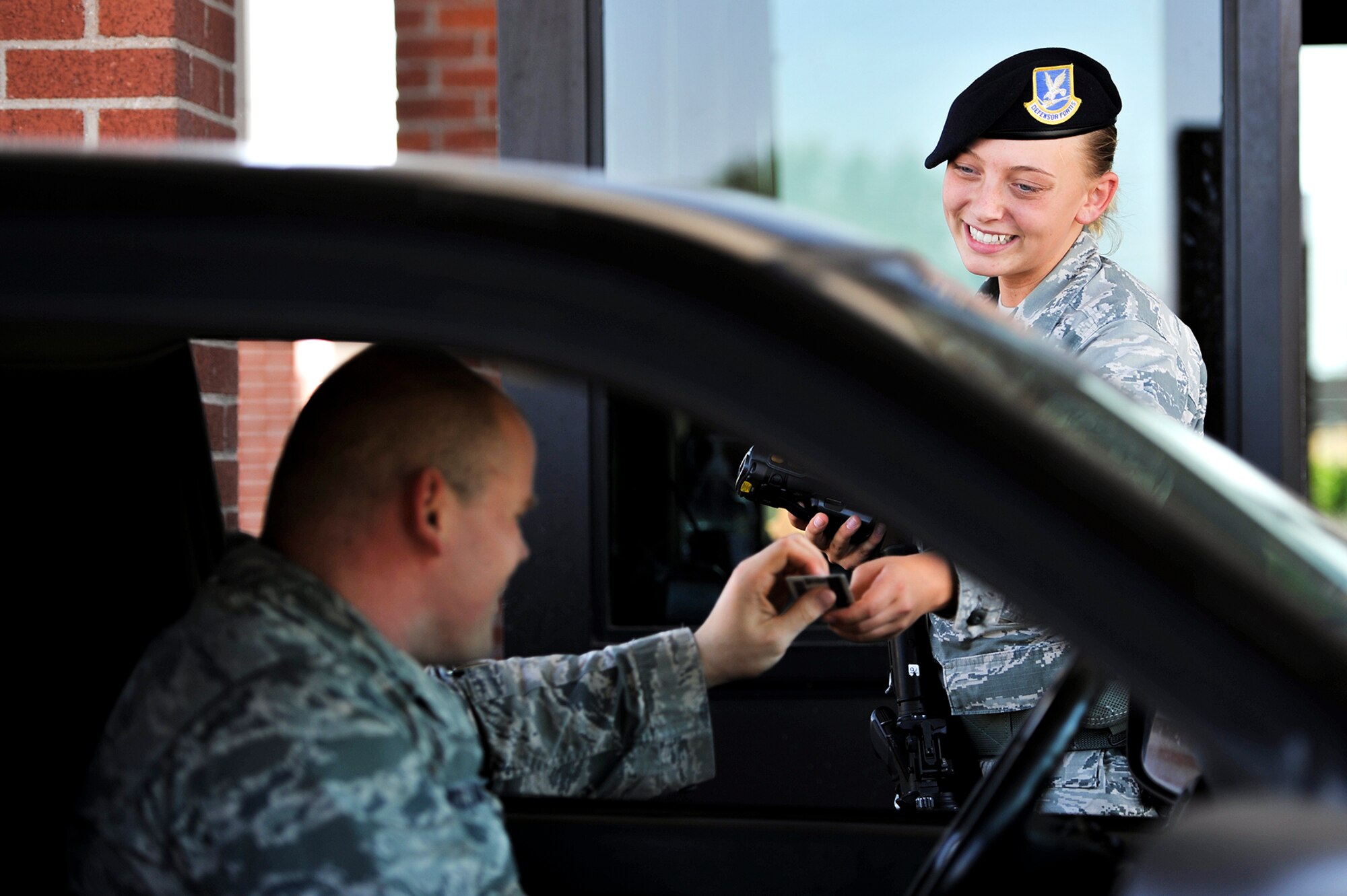 U.S. Air Force Airman 1st Class Karlie J. Johnson, 17th Security Forces Squadron entry controller, checks identification cards at the North gate on Goodfellow Air Force Base, Texas, Aug. 24, 2015. Guarding the gate is one of several duties security forces members perform on base. (U.S. Air Force photo by Airman 1st Class Devin Boyer/Released)