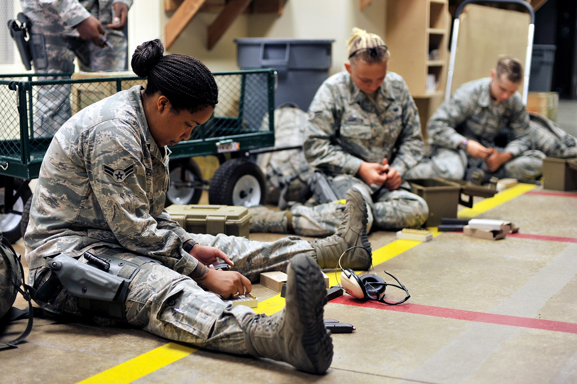 U.S. Air Force Airman 1st Class Danielle E. Tears and Airman 1st Class Karlie J. Johnson, 17th Security Forces Squadron entry controllers, and Senior Airman Morghan E. Poitras, 17th SFS reports and analysis clerk, load ammunition during weapons qualification training at the firing range on Goodfellow Air Force Base, Texas, Aug. 25, 2015. The Security Forces Airmen fired their weapons at targets set at various distances to qualify. (U.S. Air Force photo by Airman 1st Class Devin Boyer/Released)