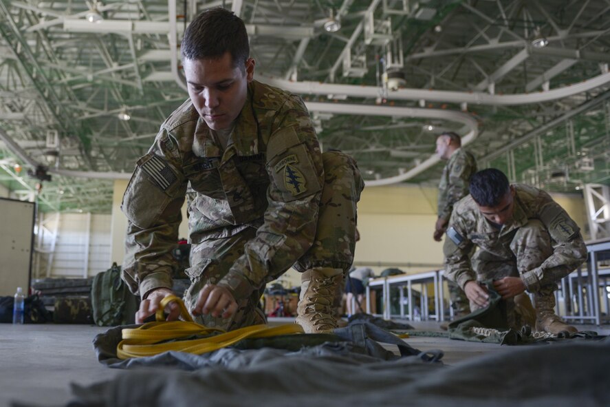 Staff Sgt. Brian Wright, 1st Battalion, 1st Special Operations Group (Airborne), roles a parachute cord before boarding a C-130 Hercules during the 2015 Japanese-American Friendship Festival at Yokota Air Base, Japan, Sept. 20, 2015. More than 40 Soldiers jumped from C-130s during the two-day event, highlighting Yokota's airdrop capability to the crowd; more than 185,000 people attended the festival. (U.S. Air Force photo by Staff Sgt. Cody H. Ramirez/Released)