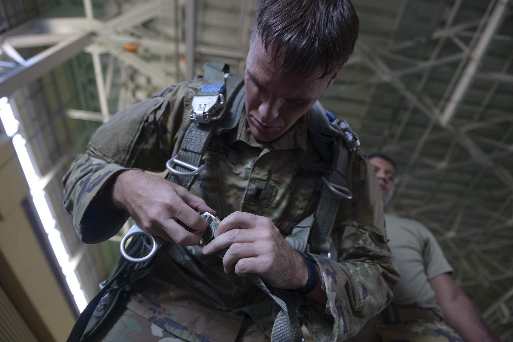 US Army Lt. John Donelson, 1st Battalion, 1st Special Operations Group (Airborne), dons a parachute pack during the 2015 Japanese-American Friendship Festival at Yokota Air Base, Japan, Sept. 20, 2015. More than 40 Soldiers jumped from C-130s during the two-day event, highlighting Yokota's airdrop capability to the crowd; more than 185,000 people attended the festival. (U.S. Air Force photo by Staff Sgt. Cody H. Ramirez/Released)