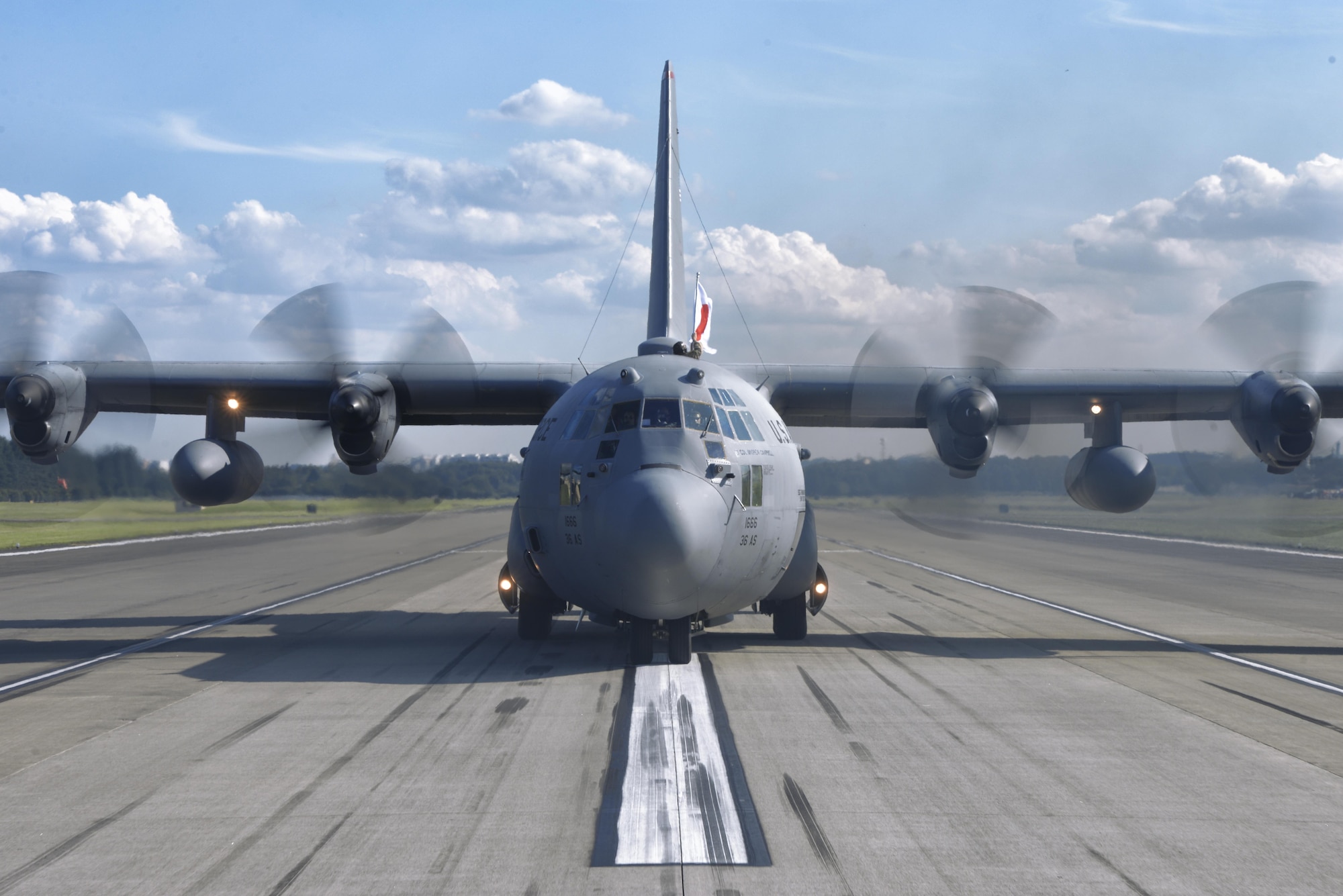 A U.S. soldier with the 1st Battalion, 1st Special Forces Group (Airborne), holds an Japanese Flag outside of a C-130 Hercules at Yokota Air Base, Japan, during the Japanese-American Friendship Festival, Sept. 19, 2015. Paratroopers jumped from the C-130H as part of an aerial demonstration in front of a crowd of tens of thousands. (U.S. Air Force photo by Airman 1st Class Delano Scott/Released)