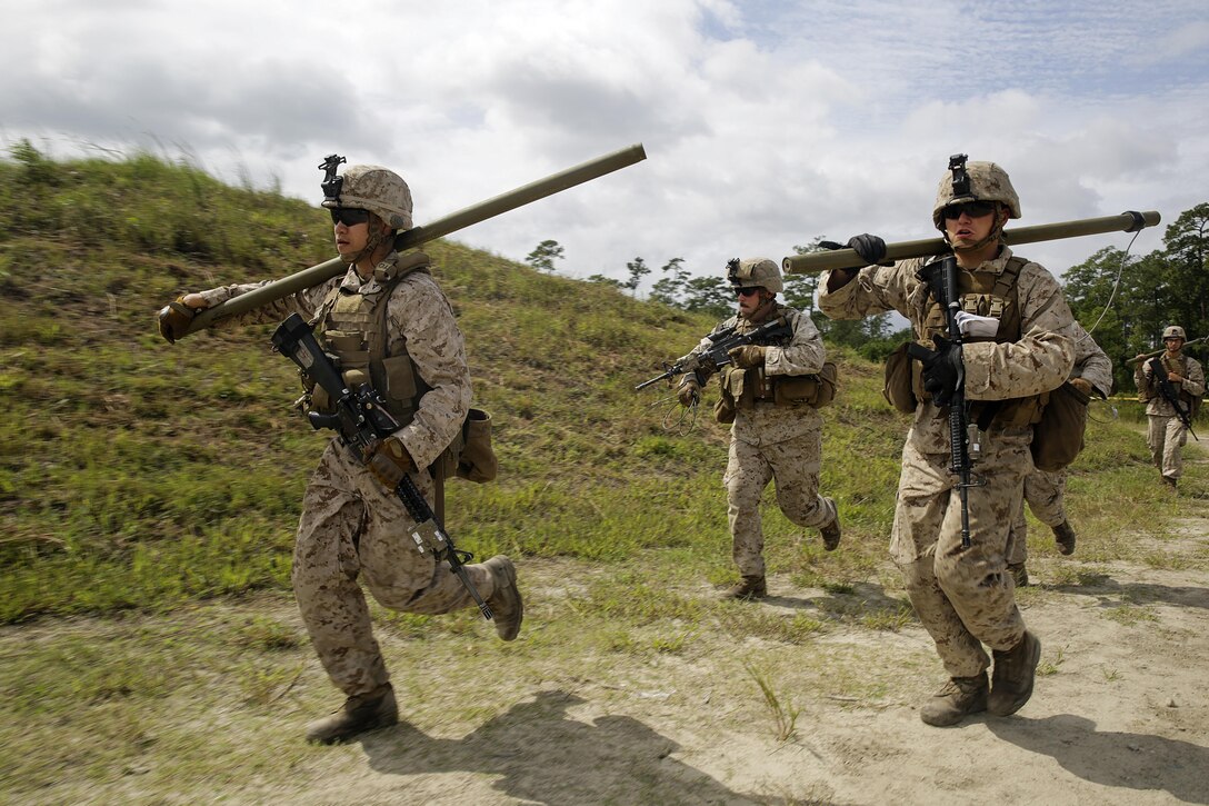 Marines with 2nd Battalion, 2nd Marine Regiment rush to a wire trap to set up a bangalore charge to destroy the trap during a demolitions exercise with 2nd Combat Engineer Battalion at Engineer Training Area  7 on Camp Lejeune, N.C., Sept. 22, 2015.  Marines with 2/2 increased their proficiency and knowledge with various charges and techniques with the help of 2nd CEB.  (U. S. Marine Corps photo by Cpl. Alexander Mitchell/released)