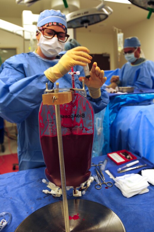 A nurse transfers bone marrow donated from U.S. Air Force Tech. Sgt. Bruce Davis, 527th Space Aggressor Squadron radio frequency transmission supervisor, to a collection bag at Banner-University Medical Center in Tucson, Ariz., July 2015. Davis’ marrow extraction took place at Banner UMC because one of its specialty services includes extensive cancer treatment. (U.S. Air Force photo by Airman 1st Class Chris Drzazgowski/Released)