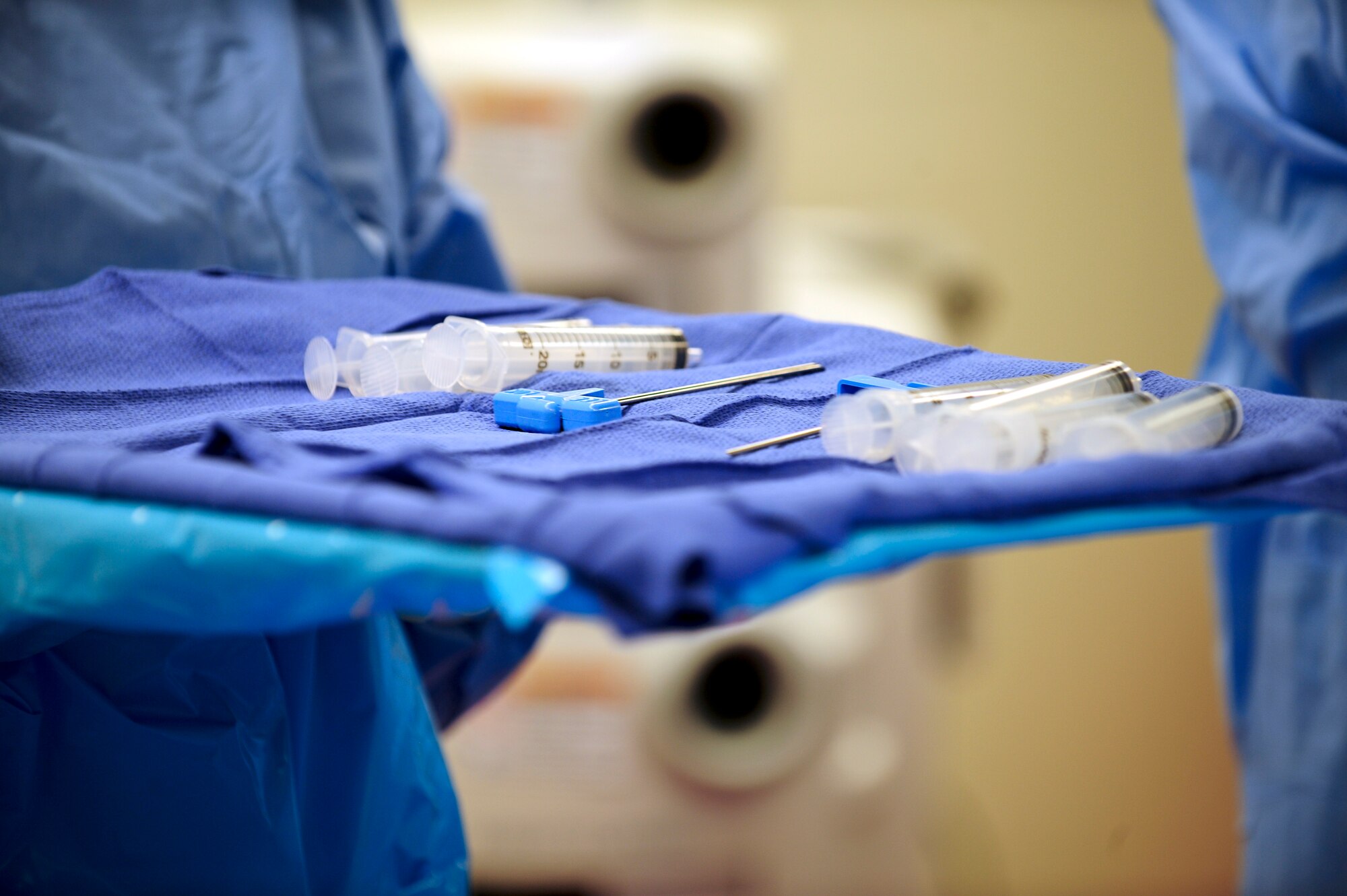 A nurse carries a tray of biopsy needles and syringes to an operating table during a bone marrow collection procedure at Banner-University Medical Center in Tucson, Ariz., July 2015. The needles are placed in the left and right sides of a donor’s lower back and are used to extract 1-2 liters of rich marrow from the hips. (U.S. Air Force photo by Airman 1st Class Chris Drzazgowski/Released)