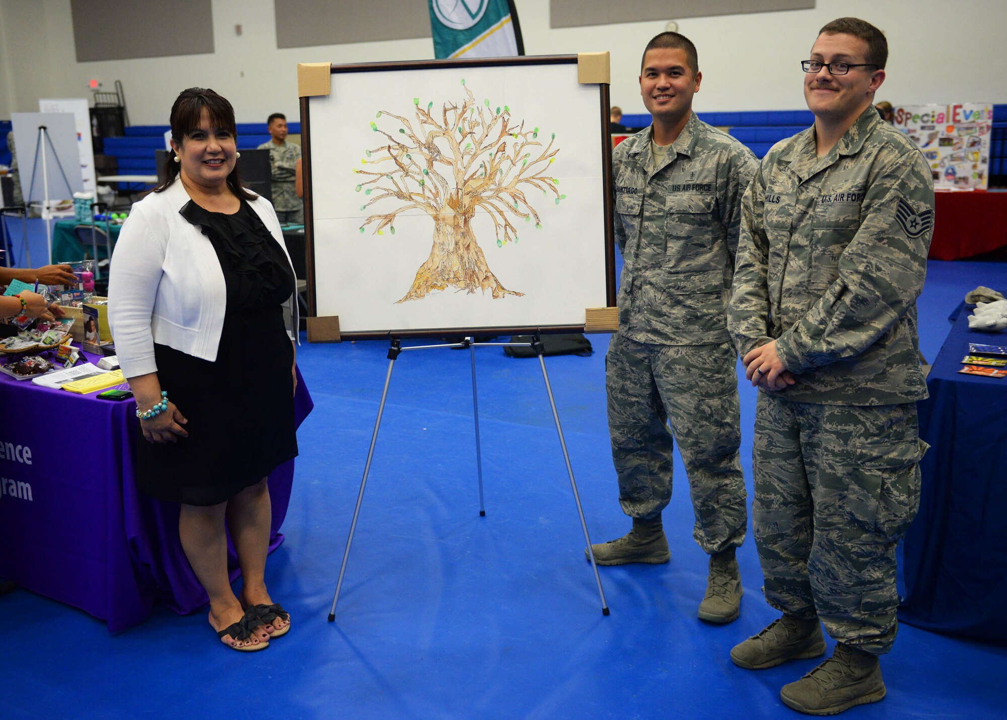 Lori Naputi, 36th Medical Operations Squadron education services facilitator, Staff Sgt. Carlo Santiago, 36th MDOS mental health NCO in charge, and Staff Sgt. Christian Hills, 36th MDOS mental health technician, stand beside the “Tree of Life” artwork Sept. 24, 2015, at Andersen Air Force Base, Guam. Individuals were invited to leave a finger print leaf if suicide or domestic violence has ever impacted their lives.  Representatives from the 36th Medical Operations Squadron held activities throughout September to raise awareness for suicide prevention and domestic violence. (U.S. Air Force photo by Senior Airman Joshua Smoot/Released)