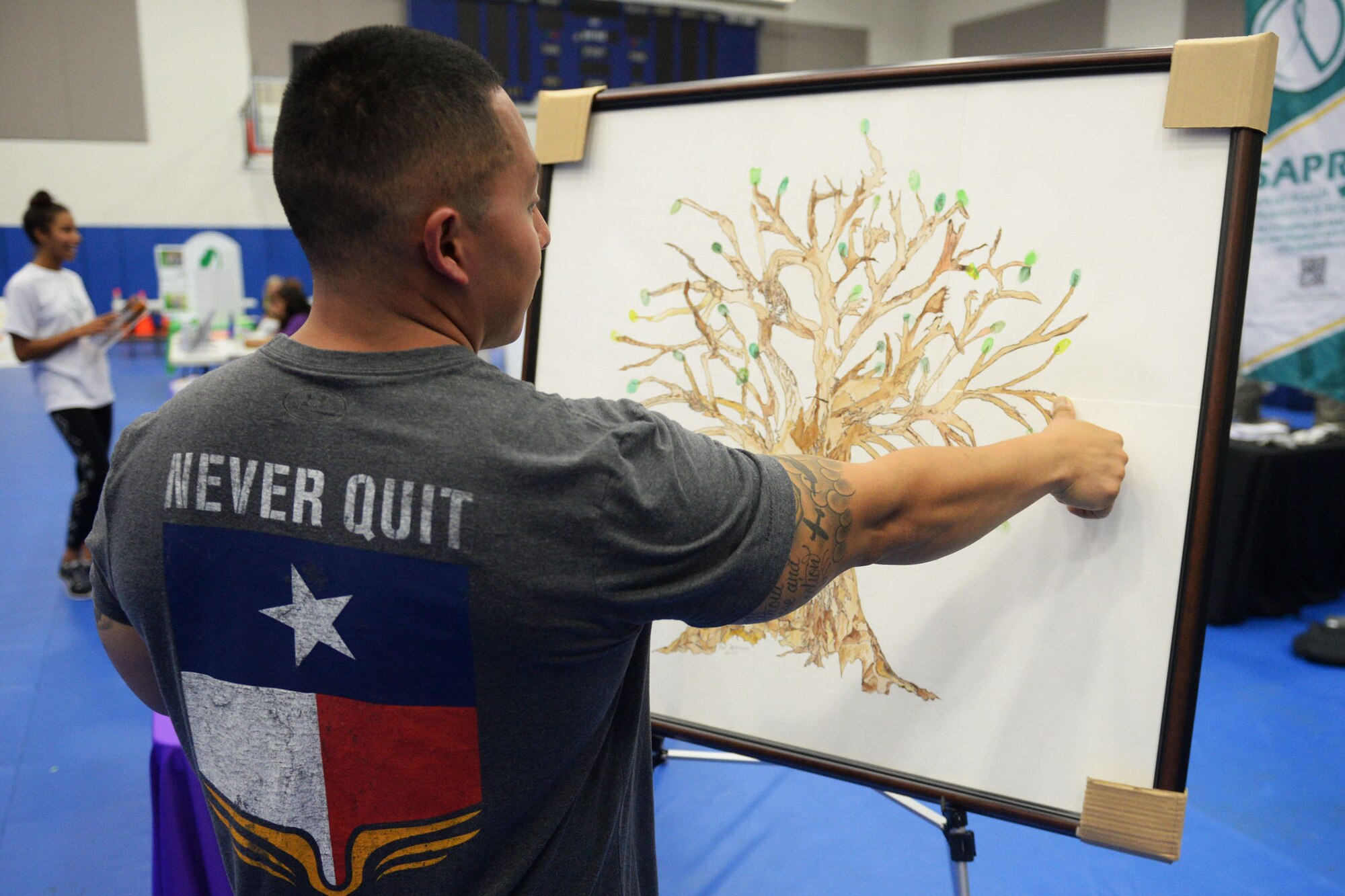 A Team Andersen member leaves a fingerprint on the “Tree of Life” artwork Sept. 24, 2015, at Andersen Air Force Base, Guam. Individuals were invited to leave a finger print leaf if suicide or domestic violence has ever impacted their lives.  Representatives from the 36th Medical Operations Squadron held activities throughout September to raise awareness for suicide prevention and domestic violence. (U.S. Air Force photo by Senior Airman Joshua Smoot/Released)