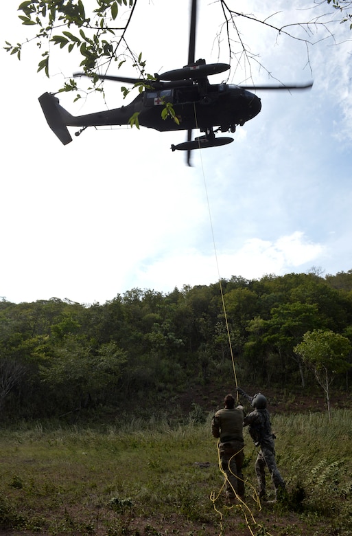 Service members from the 1-228th Aviation Regiment and the Special Operations Command Forward (Central America)guide a litter with a simulated patient onto a UH-60 Blackhawk during a personnel recovery exercise Sept. 13, 2015, near Soto Cano Air Base, Honduras. The six-man SOC FWD team partnered with Joint Task Force-Bravo to recover four simulated casualties during the exercise, testing the working relationship between the two agencies. (U.S. Air Force photo by Staff Sgt. Jessica Condit)