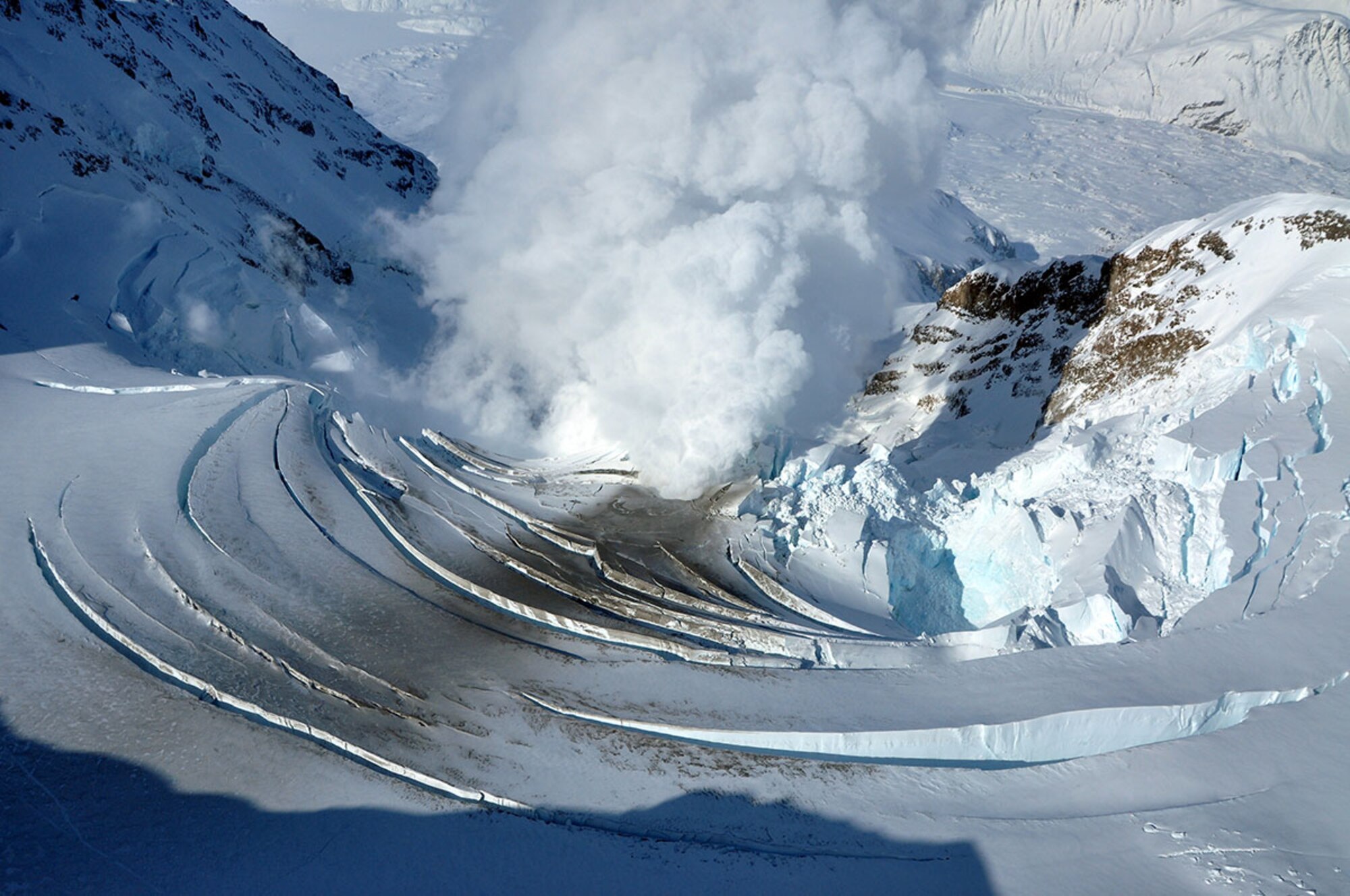 An aerial photo taken March 21, 2009, the day before Redoubt Volcano first erupted, shows the glacier that filled the crater col- 551-7526. lapsing due to the increase in ground temperature underneath. (Courtesy photos, U.S. Geological Survey)