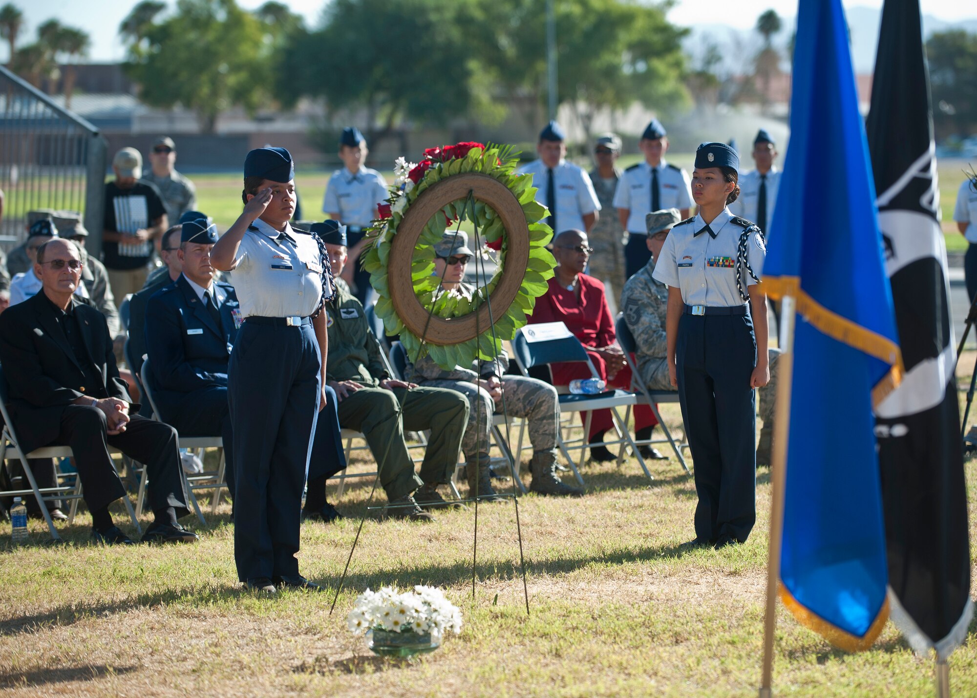 An Air Force Junior ROTC cadet from Rancho High School, Las Vegas, salutes a wreath during the Prisoners of War/Missing in Action Recognition Ceremony at Nellis Air Force Base, Nev., Sept. 18, 2015. During the ceremony, JROTC cadets placed white daisies on the wreathe while the names of deceased POWs and those still MIA were read aloud. (U.S. Air Force photo by Staff Sgt. Siuta B. Ika)