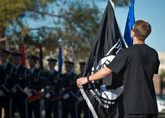 Airman Zachary Hinze, 58th Rescue Squadron pararescueman, delivers the Prisoners of War/Missing in Action Flag to the POW/MIA Recognition Ceremony at Nellis Air Force Base, Nev., Sept. 18, 2015. Hinze was part of a group of 58th/66th RQS and the U.S. Air Force Weapons School members who ran a combined 89 miles with the flag before delivering it to the ceremony. (U.S. Air Force photo by Staff Sgt. Siuta B. Ika) 
