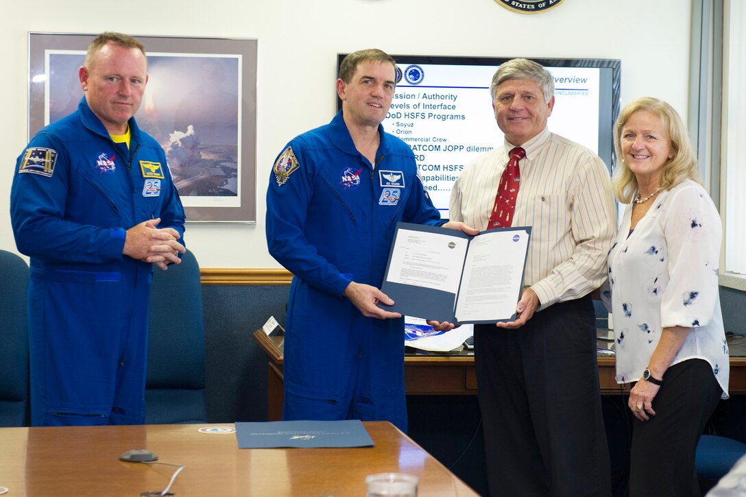 NASA Astronauts Barry "Butch" Wilmore, left, and Rex Walheim present Don Shelton, 45th Operations Group Detachment 3 deputy commander, with his wife Lisa the Silver Snoopy Award Sept. 23, 2015 for his dedicated service to Human Space Flight recovery operations at Patrick Air Force Base, Florida. The Silver Snoopy Award is an astronaut's personal award given to an individual who has made significant contributions toward enhancing the probability of mission success, or made improvements in design, administrative/technical/production techniques, business systems, flight and/or systems safety or identification and correction or preventive action for errors. (U.S. Air Force photo by Matthew Jurgens/Released)