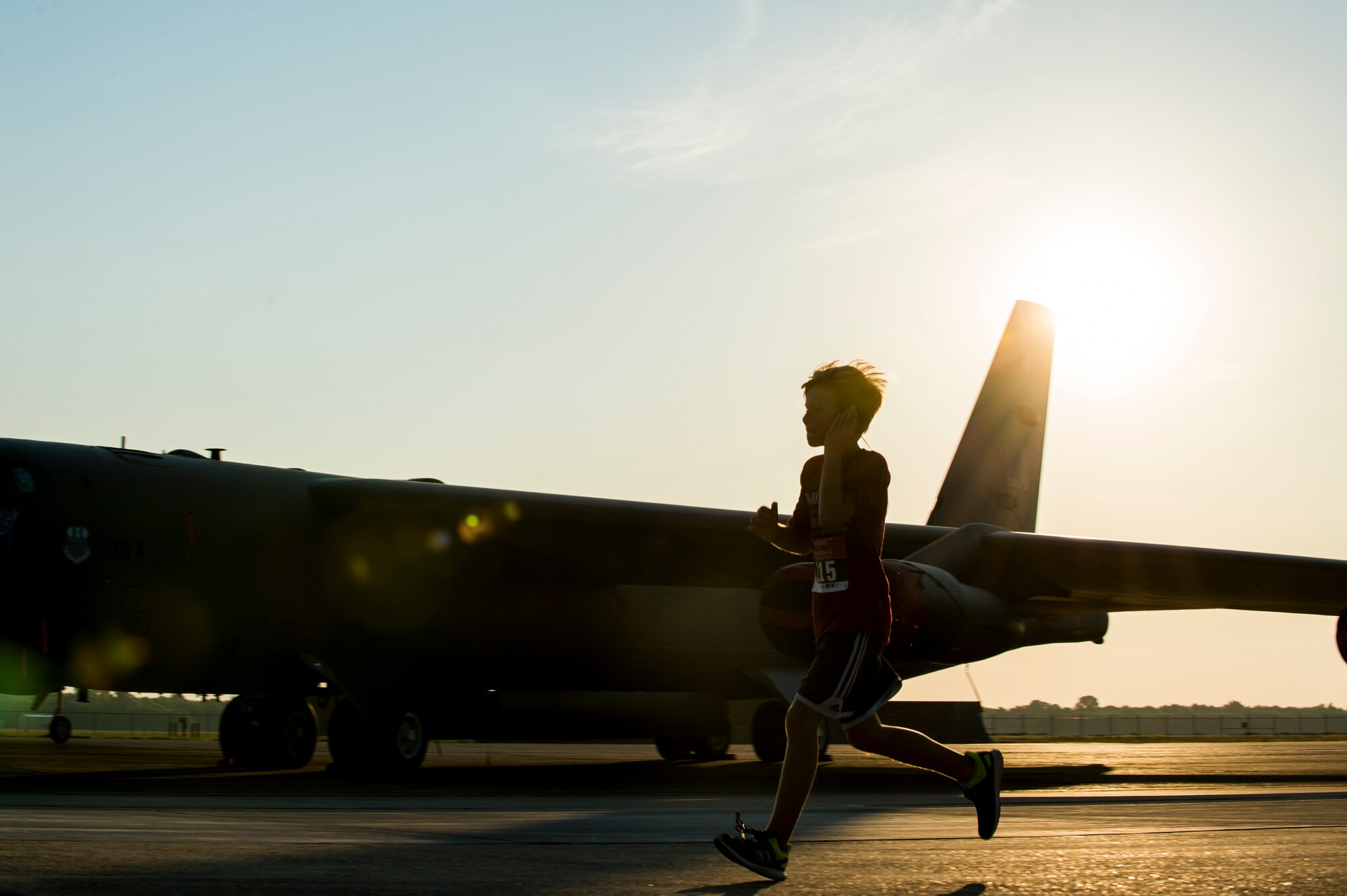The son of Maj. Christopher Miser, 608th Air Operations Center, crosses the taxiway on the flightline at Barksdale Air Force Base, La., Sept. 19, 2015, during the annual 2015 Half Marathon and 5K hosted by the 2nd Force Support Squadron. As the youngest runner, he placed first in his age group in the half marathon with a time of 1:56:51. (U.S. Air Force photo/Staff Sgt. Tyler Prince)
