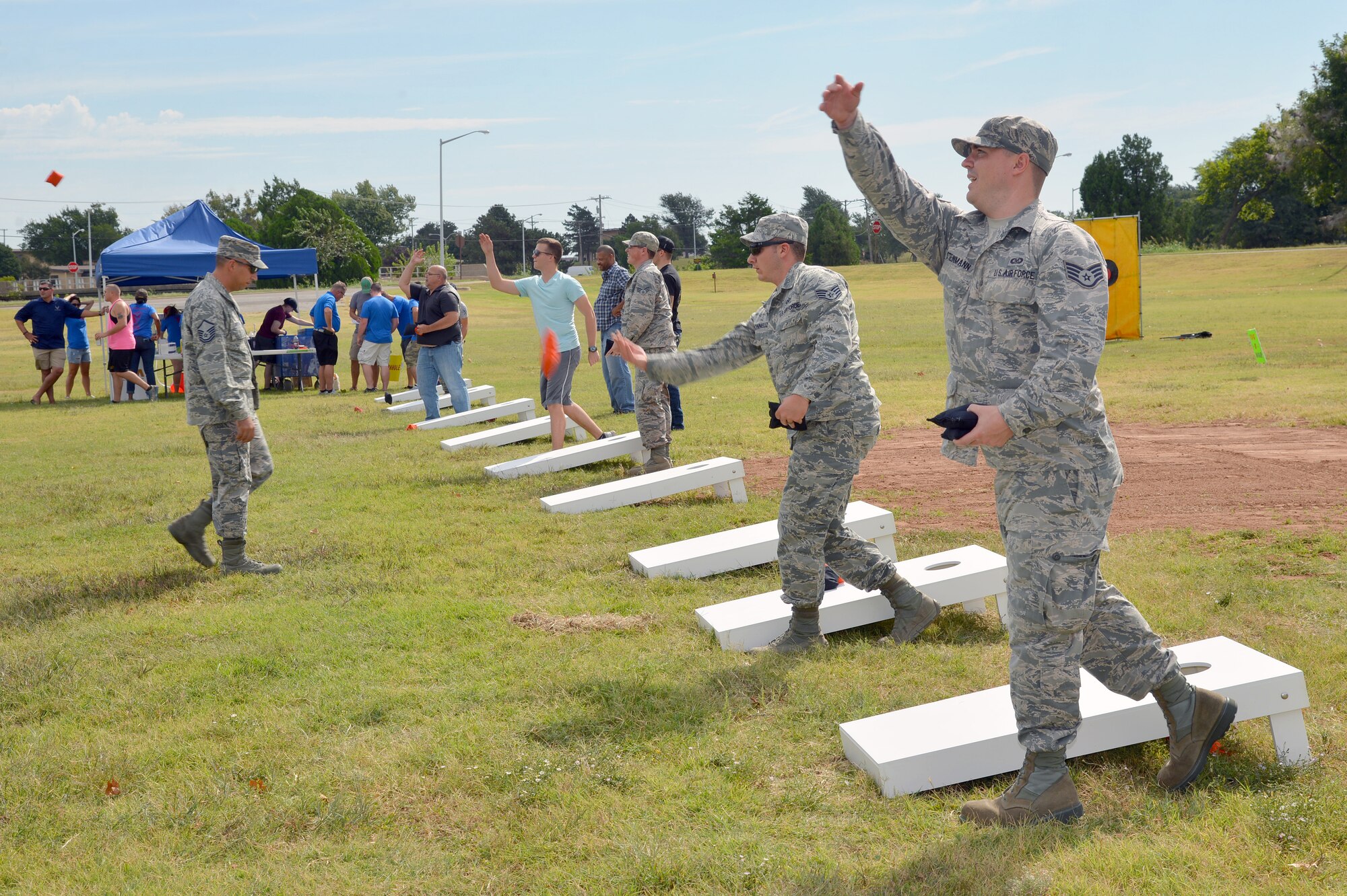Airmen participate in a bracketed cornhole tournament. Other games included tug-o-war, a three-legged race and a lip sync contest. The Tinker Coalition of Private Organizations provided $5,000 in supplies and fees free of charge to all Tinker Airmen. Approximately 950 hot dogs and 500 snow cones were handed out to the more than 700 people who came to the event. (Air Force photo by Kelly White/Released)