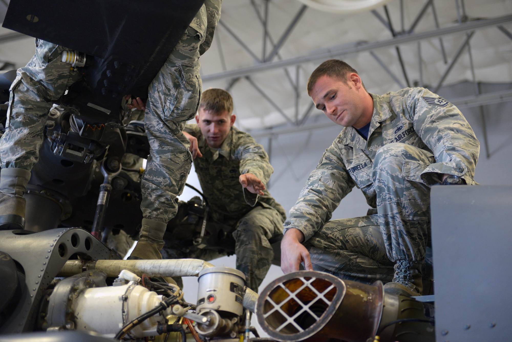 Staff Sgt. Ryan Martorella, Detachment 13, 372nd Training Squadron HH-60G Pave Hawk crew chief instructor, listens to Senior Airman Eric Miesieski, 823rd Maintenance Squadron HH-60 crew chief, during a class at the 823rd MXS hangar on Nellis Air Force Base, Nev., Sept. 19, 2015. Classes at Detachment 13 are a part of upgrade training for incoming and experienced Airmen in aircraft maintenance career fields. (U.S. Air Force photo by Airman 1st Class Rachel Loftis)