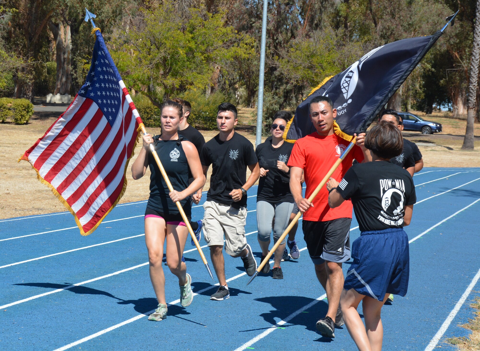 TRAVIS AIR FORCE BASE, Calif. -- As Travis Air Force Base Honor Guard Airmen and active duty delayed enlistment trainees approach, 349th Air Mobility Wing Command Chief Master Sgt. Ericka Kelly accepts the POW/MIA flag, during the 24-hour Vigil Run Sept. 18, 2015. (U.S. Air Force photo/Ellen Hatfield)