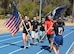 TRAVIS AIR FORCE BASE, Calif. -- As Travis Air Force Base Honor Guard Airmen and active duty delayed enlistment trainees approach, 349th Air Mobility Wing Command Chief Master Sgt. Ericka Kelly accepts the POW/MIA flag, during the 24-hour Vigil Run Sept. 18, 2015. (U.S. Air Force photo/Ellen Hatfield)