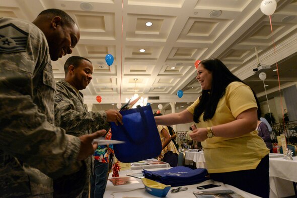 Master Sgt. Shaylor Bernard, Jeanne Holm Center Support Directory superintendent, left, and Tech. Sgt. Jason Becoat, 42nd Air Base Wing Ground Safety non-commissioned officer in charge, right, gather information from Cydney Hartner, Food For The Poor, Inc. program specialist, about the services the organization provides during the 2015 Combined Federal Campaign kickoff event Sept. 22, 2015, held at Maxwell Air Force Base, Alabama. Food for the Poor provides food, medicine and shelter to the poor in Latin America and the Caribbean. (U.S. Air Force photo by Airman 1st Class Alexa Culbert)