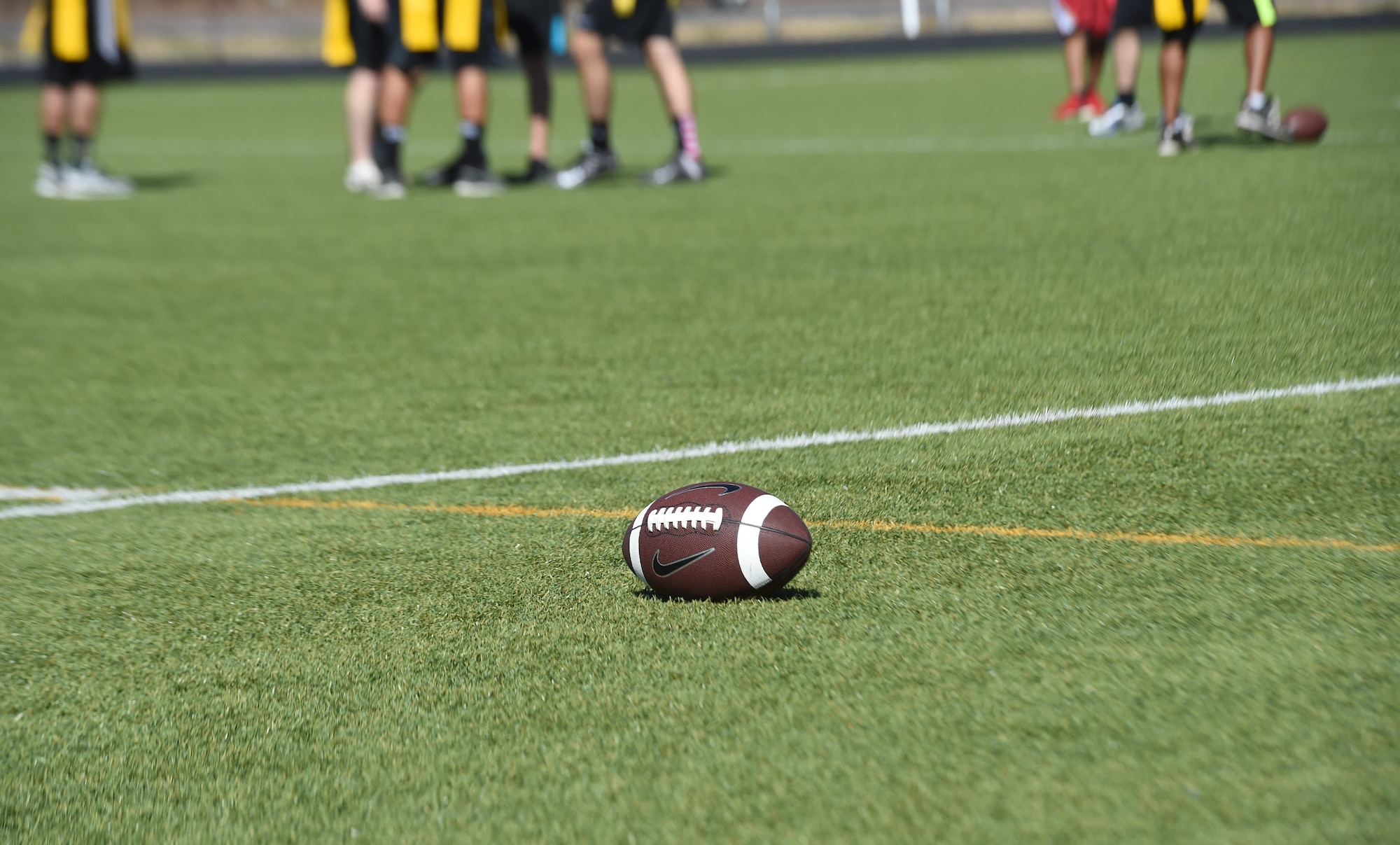 Junior enlisted military members huddle during a flag football game against Buckley 5/6 Association members Sept. 23, 2015, at the all-purpose field on Buckley Air Force Base, Colo. The game was a chance for members to engage in friendly competition, while allowing NCOs the opportunity to mentor younger Airmen in a non-professional setting. (U.S. Air Force photo by Airman 1st Class Samantha Meadors/Released)