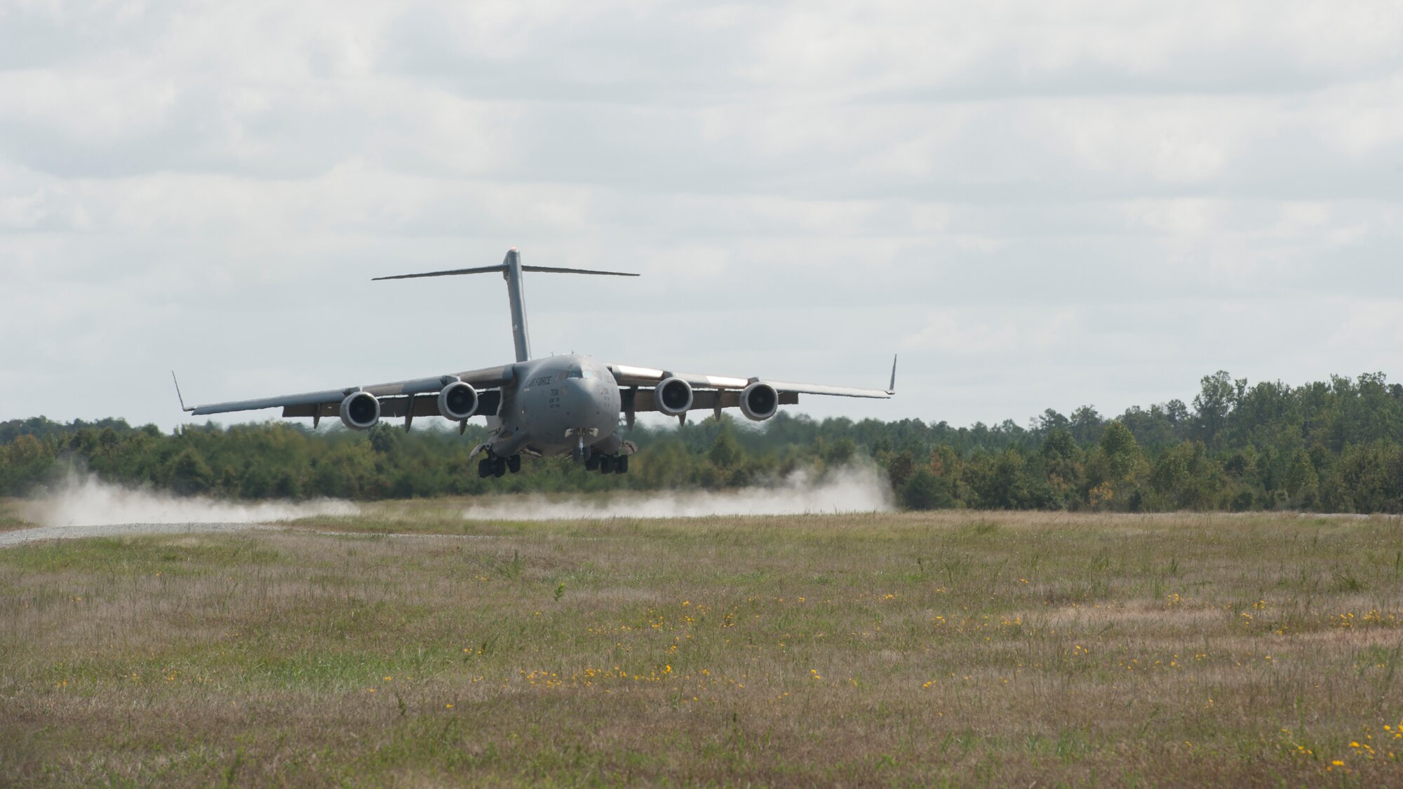 A C-17A Globemaster III, operated by the 3d Airlift Squadron, moments before landing on a dirt and gravel runway during a semi-prepared runway operations (SPRO) training mission Sept. 23, 2015, at Fort A.P. Hill, Va. SPRO training prepares aircrews to operate C-17s in austere, rugged runway conditions to deliver troops, equipment and military hardware to  forward deployed locations. (U.S. Air Force photo/Airman 1st Class Zachary Cacicia)