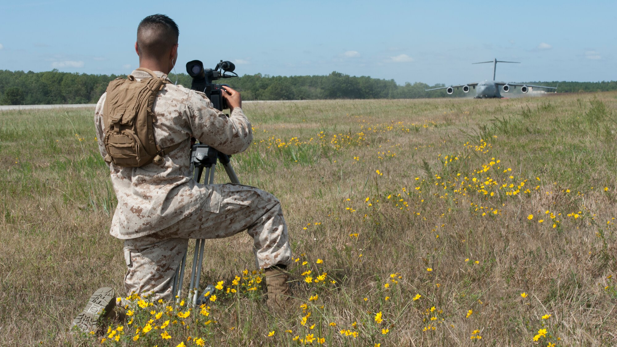 Lance Cpl. Manuel Serrano, Defense Information School (DINFOS) student, films a C-17A Globemaster III during a semi-prepared runway operations (SPRO) training mission Sept. 23, 2015, at Fort A.P. Hill, Va. Serrano and other DINFOS students travelled from Fort Meade, Md., to use the training operations for a class project. (U.S. Air Force photo/Airman 1st Class Zachary Cacicia)