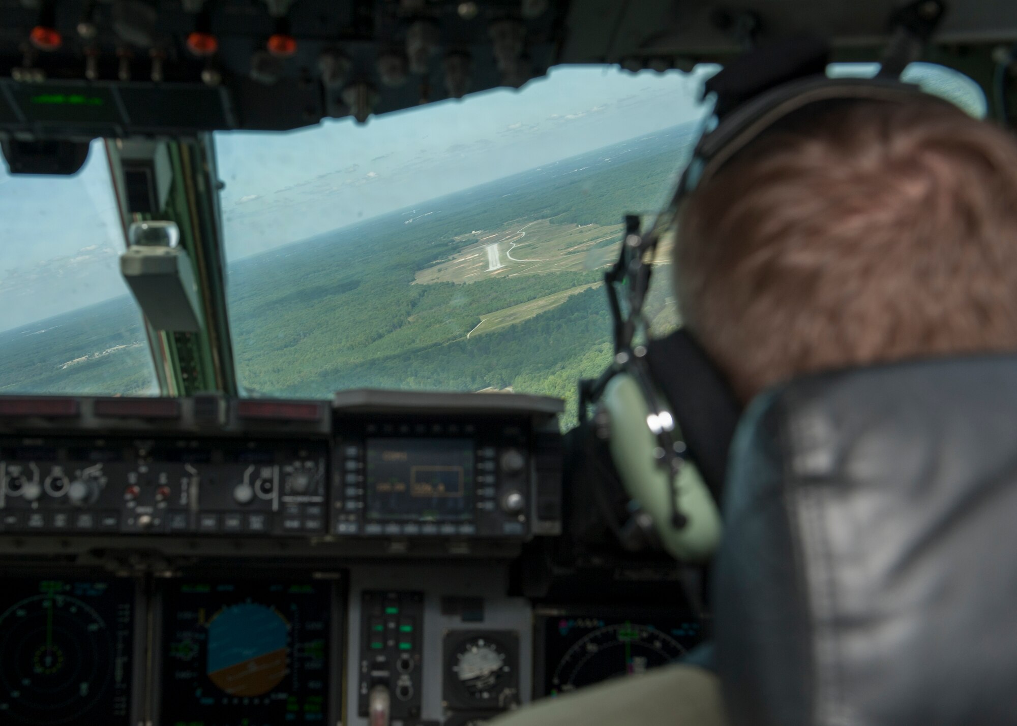 Lt. Col. Mark Radio, 436th Airlift Wing Safety chief, pilots a C-17A Globemaster III in position with a dirt and gravel runway in the distance during a semi-prepared runway operations (SPRO) training mission Sept. 23, 2015, above Fort A.P. Hill, Va. The runway is only 90 feet wide and 3,563 feet long. (U.S. Air Force photo/Airman 1st Class Zachary Cacicia)