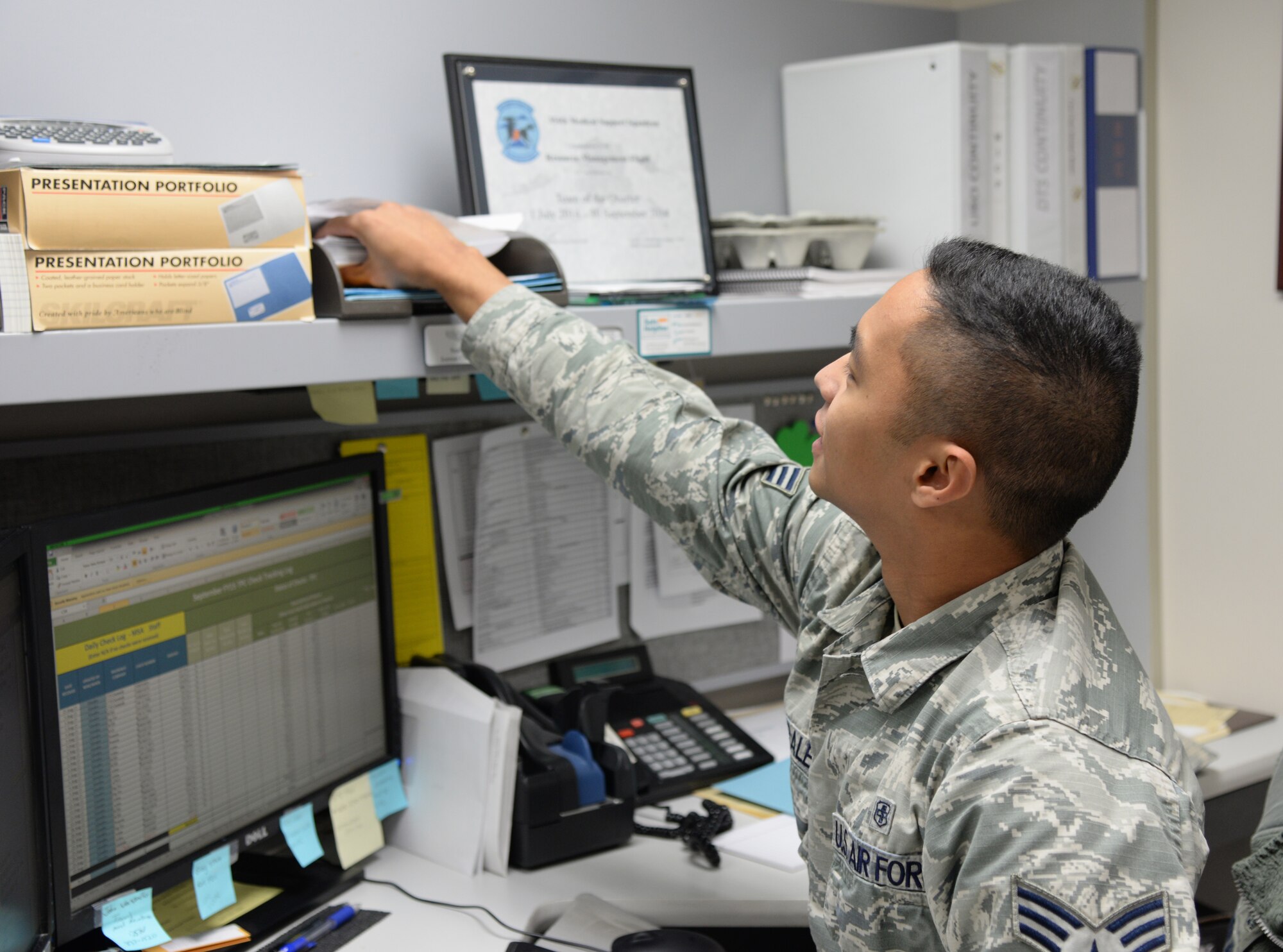 U.S. Air Force Senior Airman Noel Morales, a 354th Medical Support Squadron uniform business office manager, reaches for checks Sept. 23, 2015, at Eielson Air Force Base, Alaska. Morales receives checks from health insurance companies as part of the reimbursement program for care provided to non-active duty patients that have insurance other than TRICARE. (U.S. Air Force photo by Airman 1st Class Cassandra Whitman/Released)
